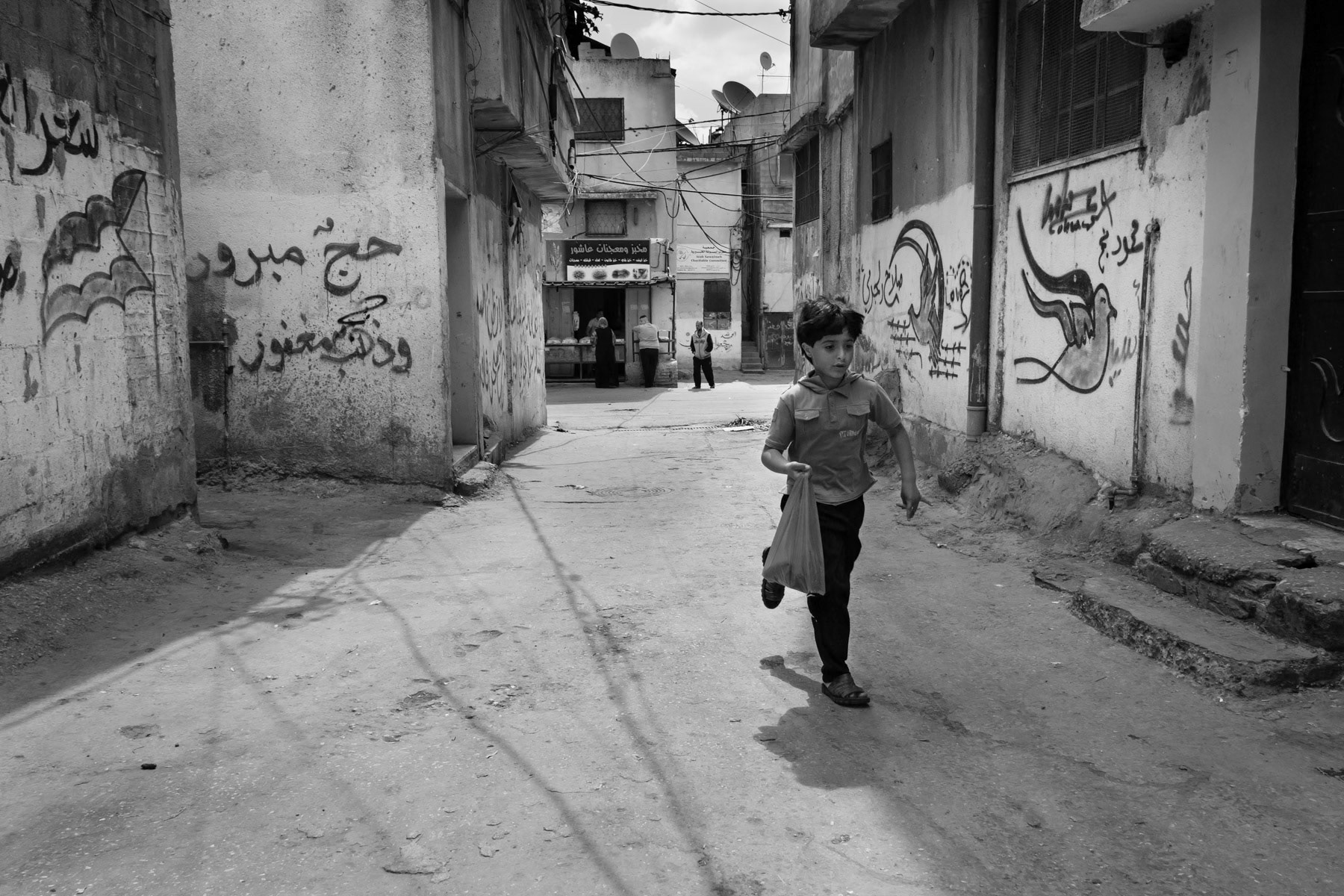 Boy running home from the grocery store, Balata Camp, Palestine, May 2014