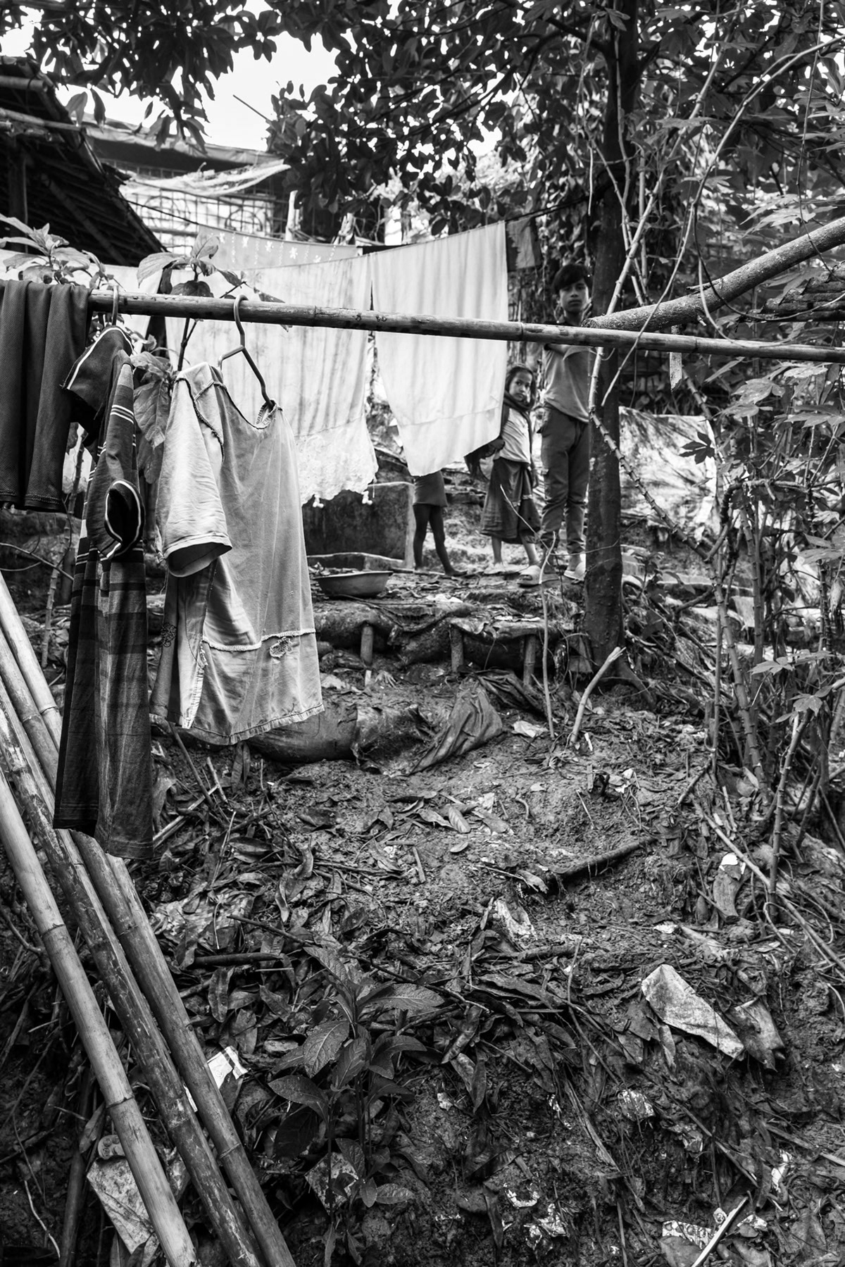 Laundry hangs to dry beside makeshift shelters on a steep hillside in the refugee camp, an area highly prone to landslides during the monsoon season. Kutupalong refugee camp, Cox's Bazar, Bangladesh, September 2025