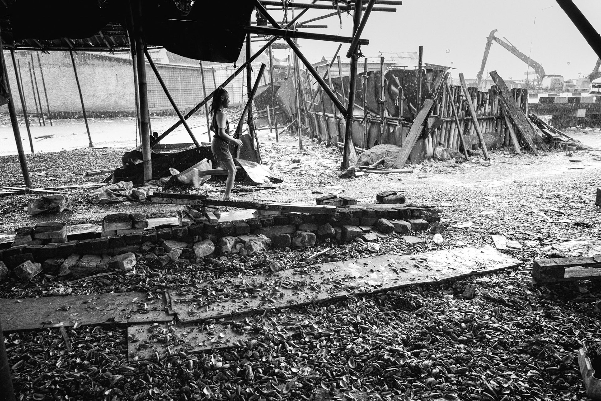 This temporary structure is a "placeholder" likely to vanish in the next super flood. In the background, excavators work frantically to patch an eroding coast that the ocean is determined to reclaim. Muara Angke, Jakarta, January 2026
