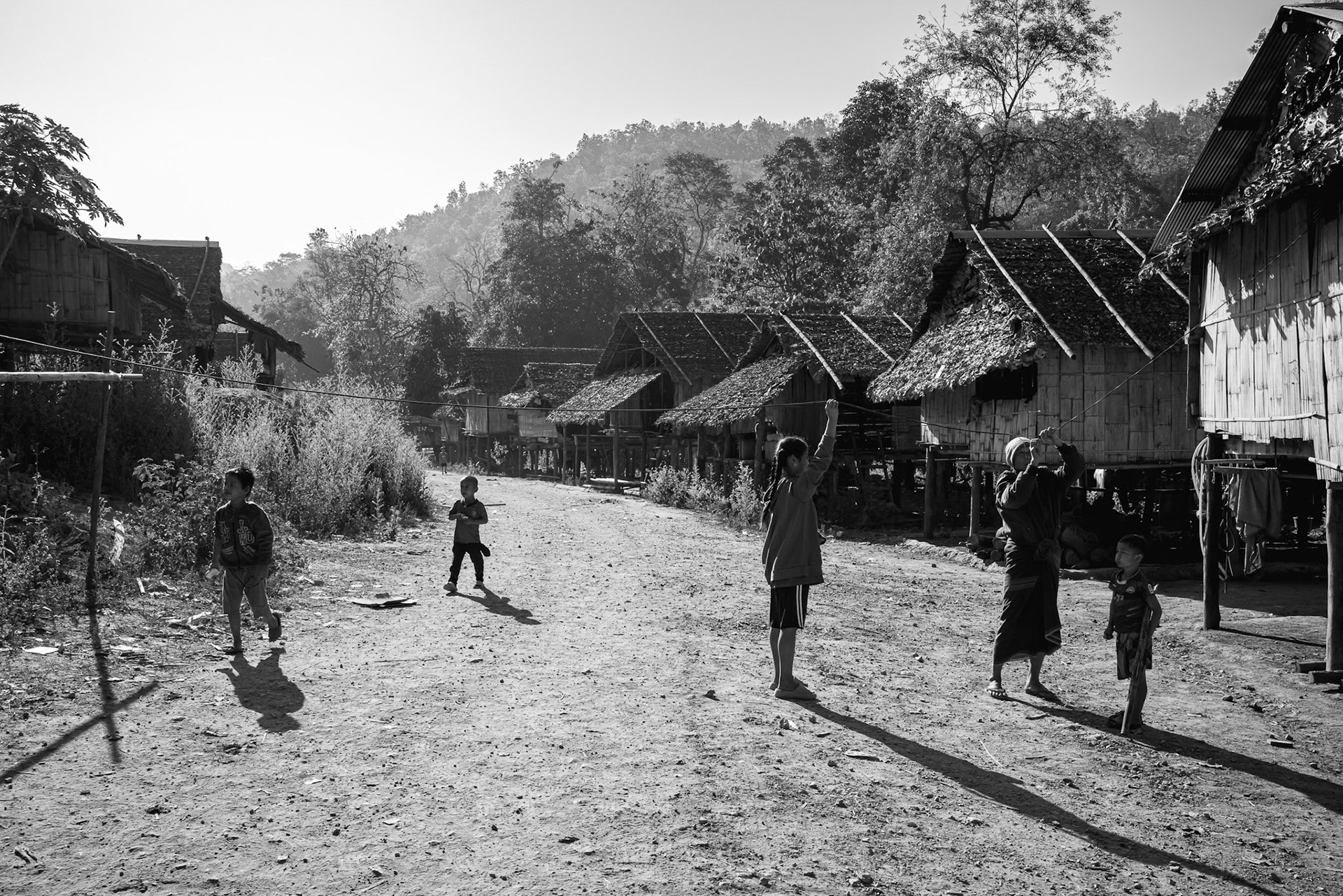 A family installing a cable on the main thoroughfare of the IDP camp. The proximity to the Thai border serves as a reminder of the thin line between safety and the ongoing civil war. Kayin State, Myanmar, January 2026