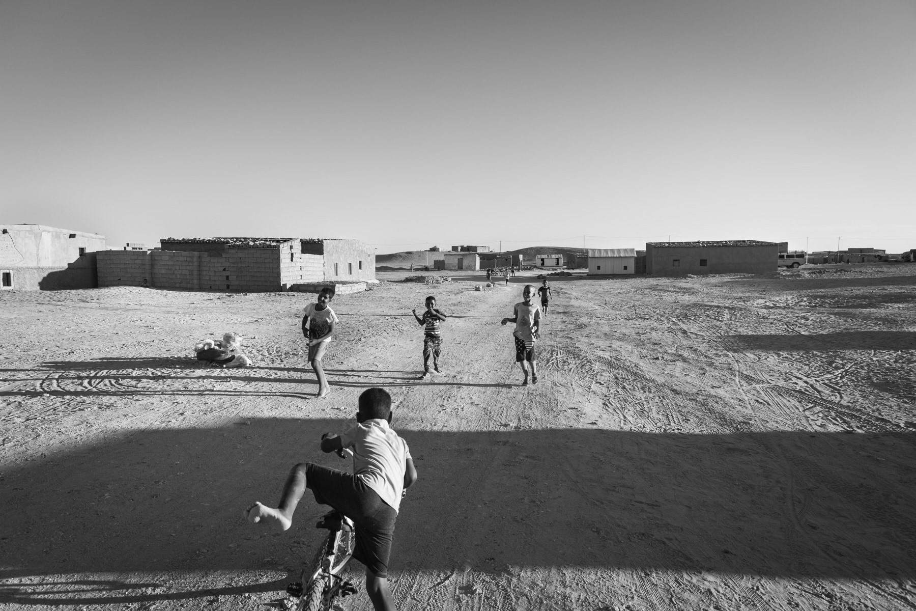 Children playing in one of the Sahrawi Refugee Camps. Saharawi refugee camps were established in the seventies in an area managed by the POLISARIO, the government in exile of the Saharawi Arab Democratic Republic (SADR). Between 120 and 150,000 refugees from the Western Sahara live in 5 refugee camps in the desert south of Tindouf. Boujdor Refugee Camp, Algeria, October 2021