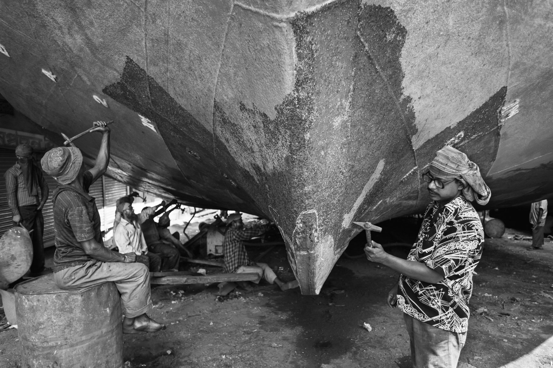Hammering off old paint for days before a fresh layer of paint, shipyards of Dhaka, Bangladesh, October 2014
