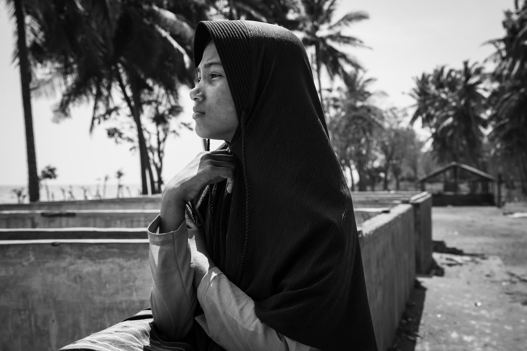 Rohingya refugee girl stranded on a beach of Sumatra after having fled her homeland and spending a month on an overcrowded wooden boat with food and water for barely one week. Thousands of Rohingya die every year trying to reach safety by boat in the region. Pidie beach camp, Aceh, Indonesia, February 2024