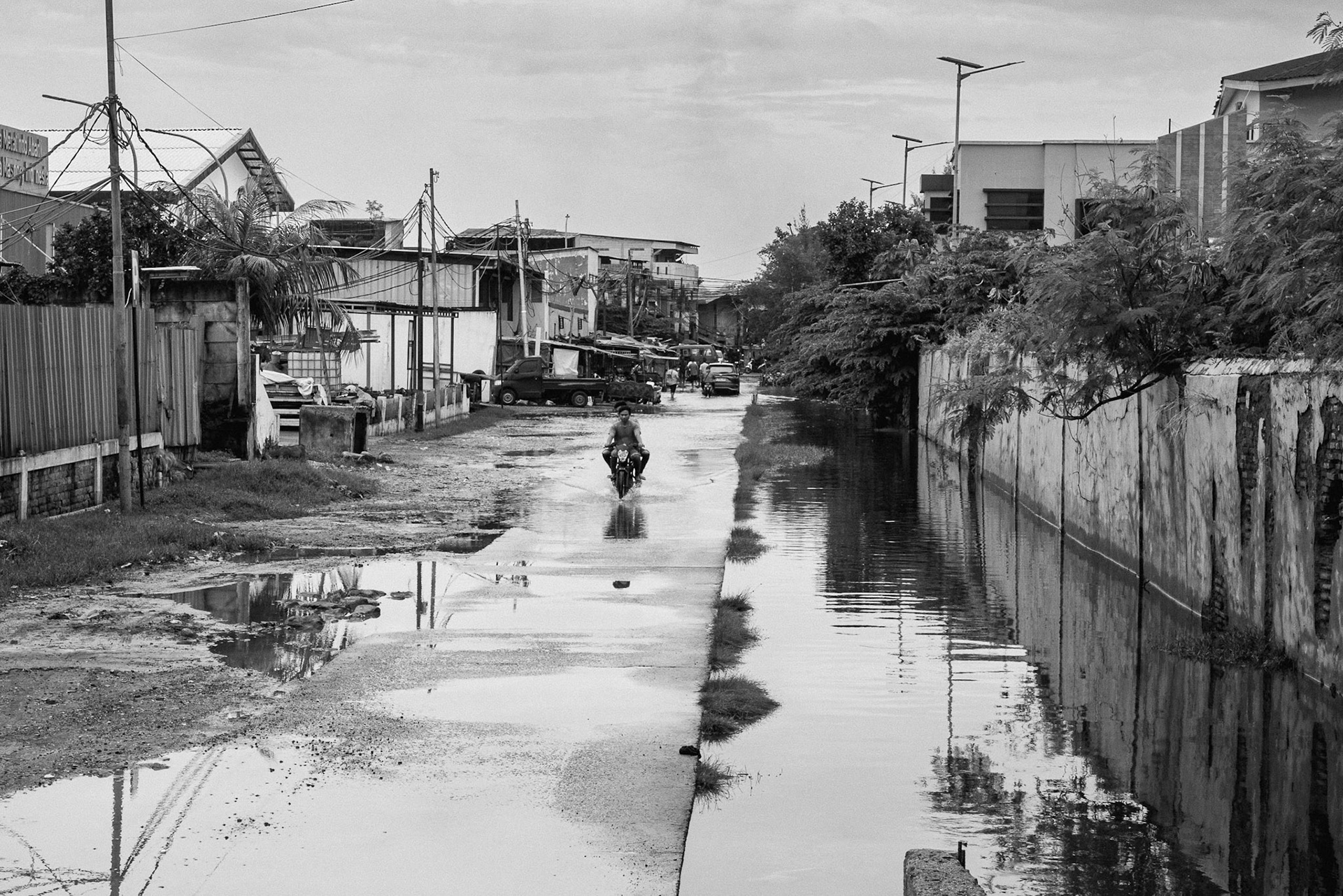 Even with the sea wall, the land behind it continues to sink. Without natural drainage or the soil-binding power of mangroves, floods are now a permanent neighbour. Muara Baru, Jakarta, January 2026