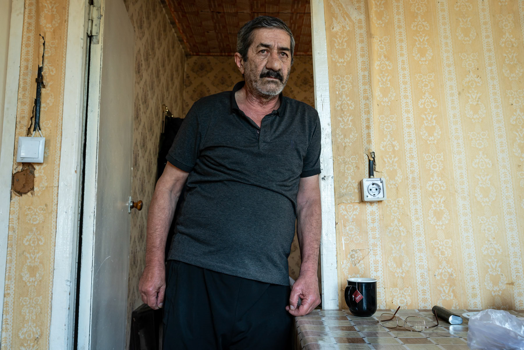 Garik, 70, a displaced person from Hadrut in Nagorno-Karabakh, has lived in a "Domik," a prefabricated Soviet-era house, since 2023. Verishen, Syunik, Armenia, September 2025