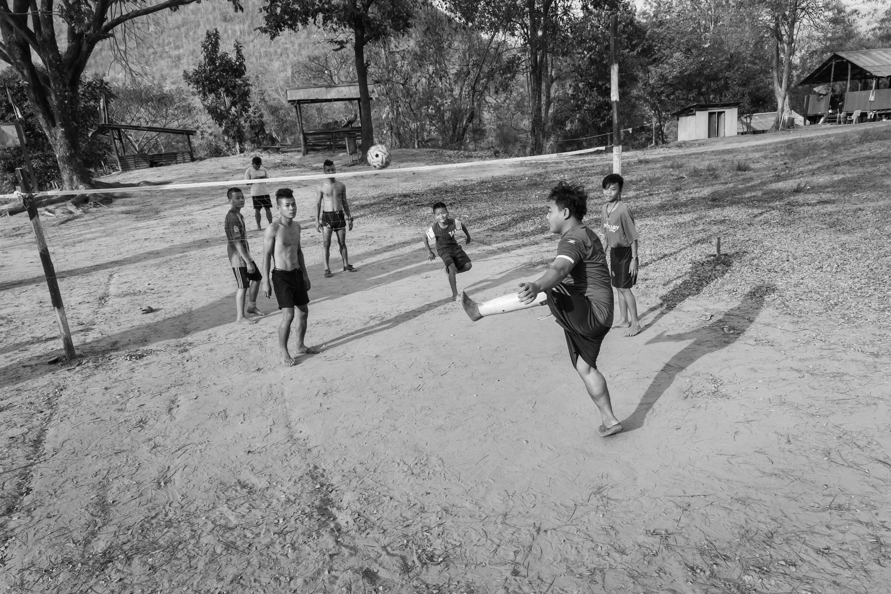 A KNDO soldier that lost his leg during the conflict, playing a traditional Burmese volley-football. Kaw Tho Lei village in Kayin State, Myanmar, March 2019