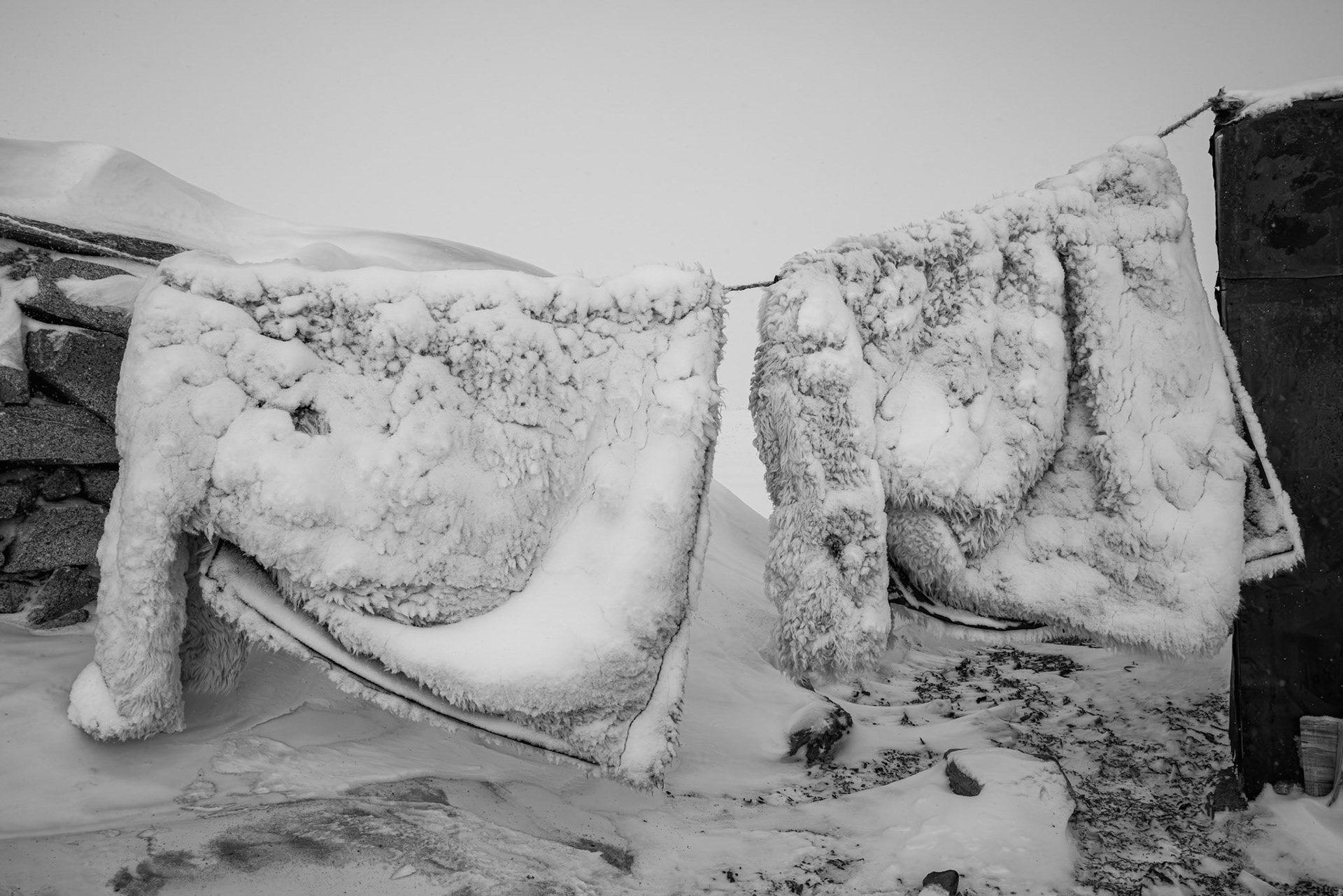 Woolen coats hung to air freeze. Herder's camp in the Gobi desert, Mongolia, December 2025