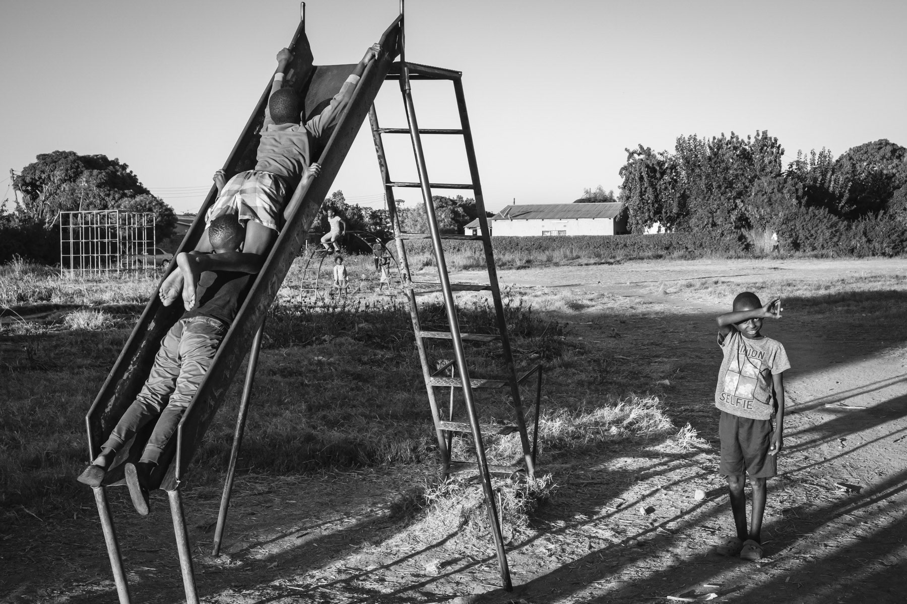 Children playing in Kasanda Mine neighbourhood, one of the most contaminated areas in Kabwe. The soil in and around the city of Kabwe contains life-threatening levels of soil particles containing lead. The amount is estimated to be 10 times above WHO safety limits and even much higher in hotspots. Children are particulary vulnerable as they have the tendency to swallow the most when playing outside in a dusty environment. Kabwe, Zambia, May 2021