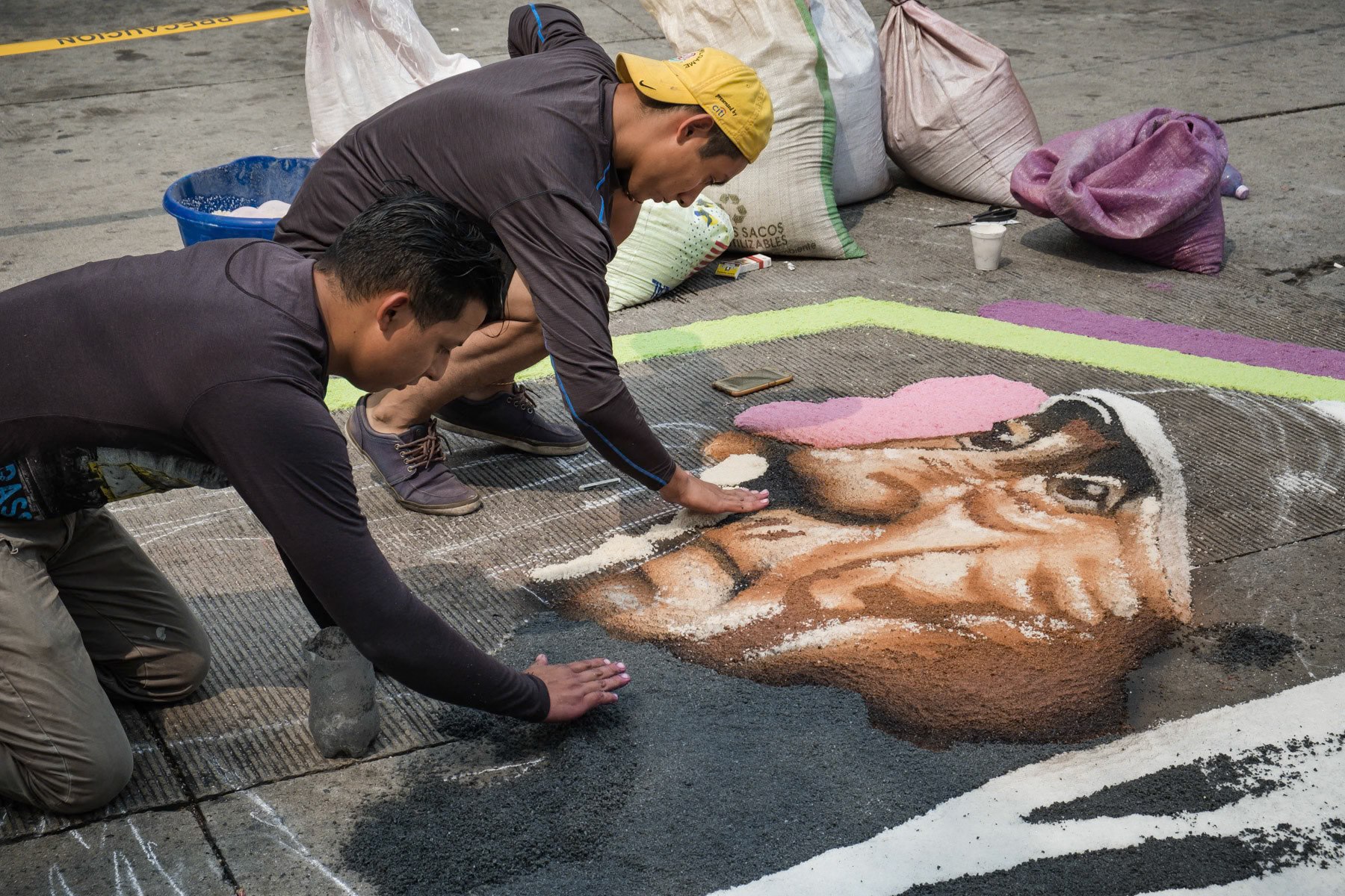 Easter preparations, where enire streets are covered with religious figures and symbols made with coulored salt. The path of salt will guide the people to the church on Easter day. Antiguo Cuscatlan, San Salvador, El Salvador, April 2019