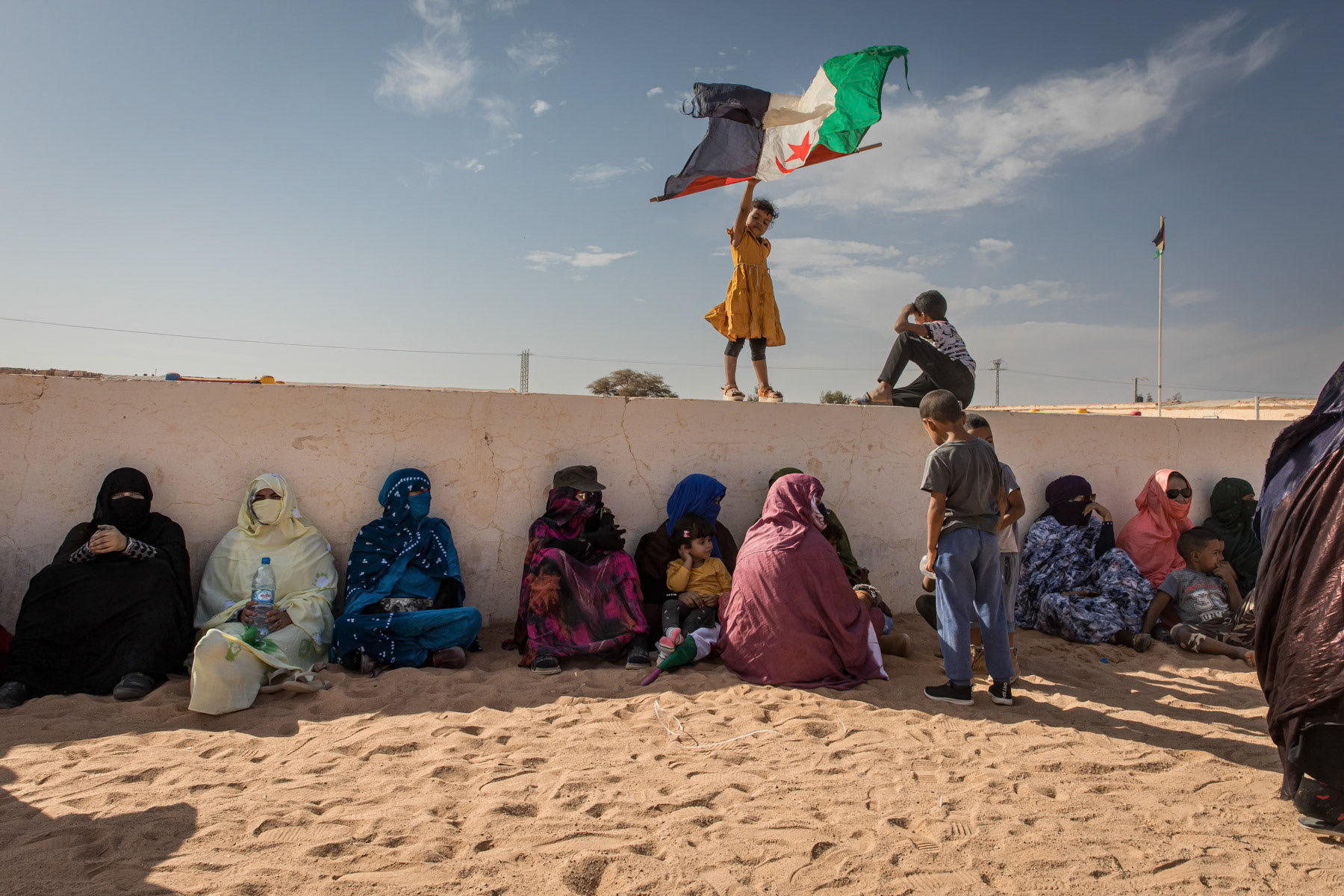 Saharawi girl waving the Saharawi National flag at a rehearsel for a ceremony for the 'Day of Unity' to take place the following day. Boujdor refugee camp in southern Algeria, October 2021