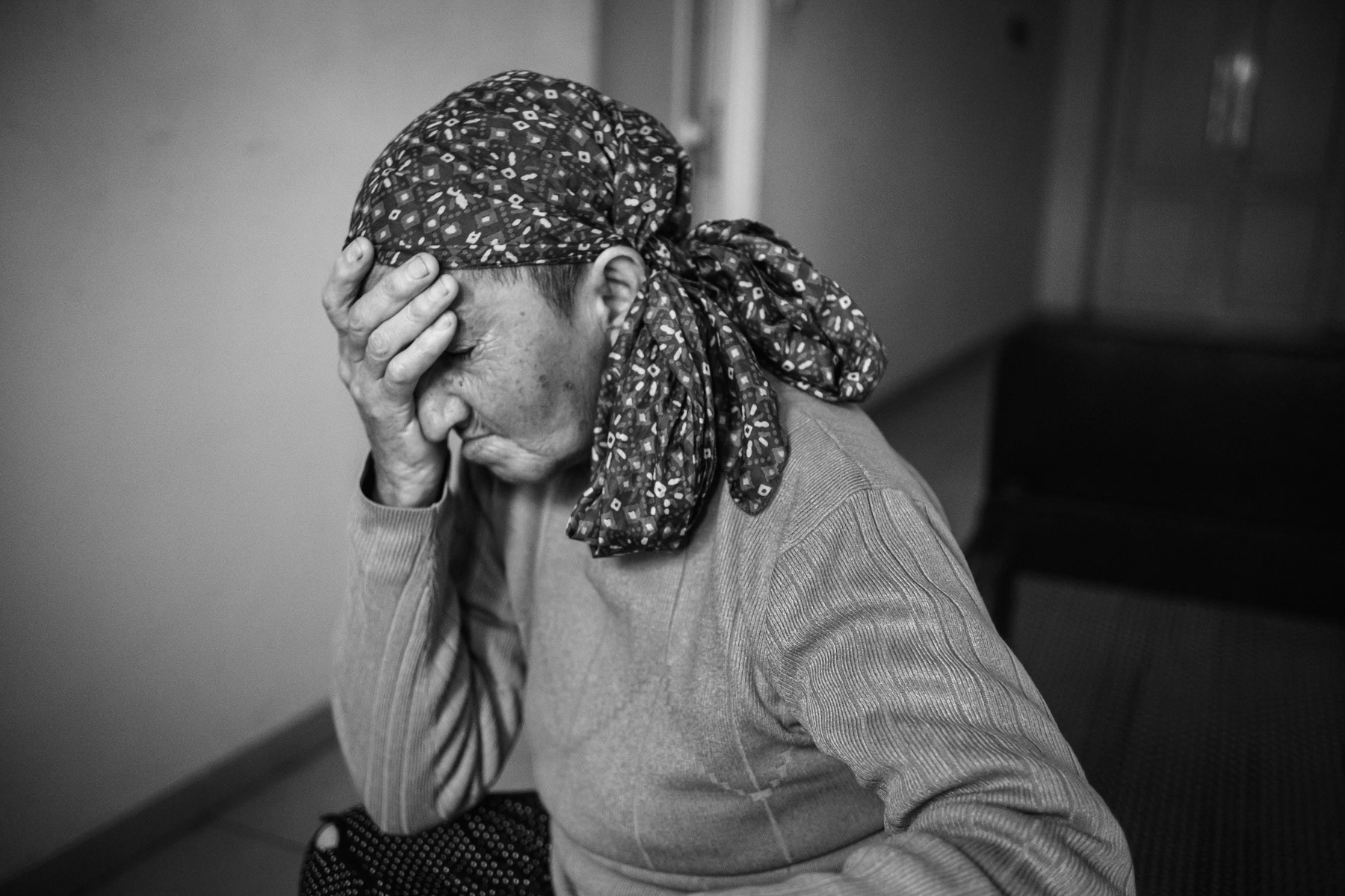 Marietta, 67, from Avetaranots village near Shushi. She was displaced from her home and lives in the building of the sports school of Askeran town with her children and grandchildren. "My younger son drove up and said mom, we cannot stay in the village, the Azerbaijani soldiers are about to enter the village. It all happened unexpectedly, we abandoned our homes and fled, we barely had time to take anything. I dont know who provoked this and the previous war, we used to trade with each other in peace in other times" Marietta says. Temporary shelter for displaced, Askeran, Nagorno-Karabakh, December 2020