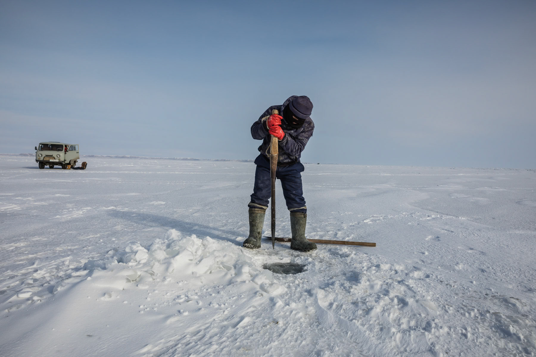 Fisherman at work on the Aral Sea during the ice fishing season. Kazakhstan, January 2019