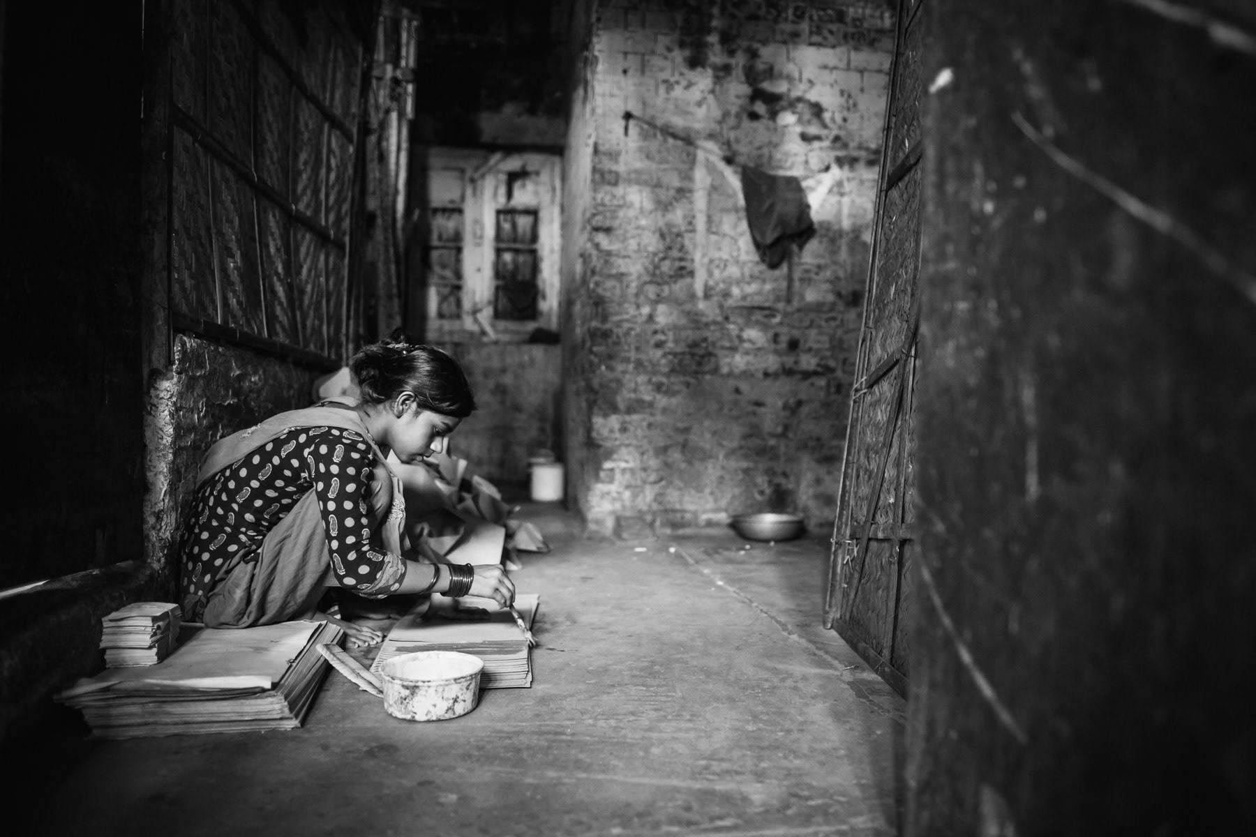 Bihari girl making paper bags. Jhowtila collective centre for Bihari people, Chittagong, Bangladesh, May 2016