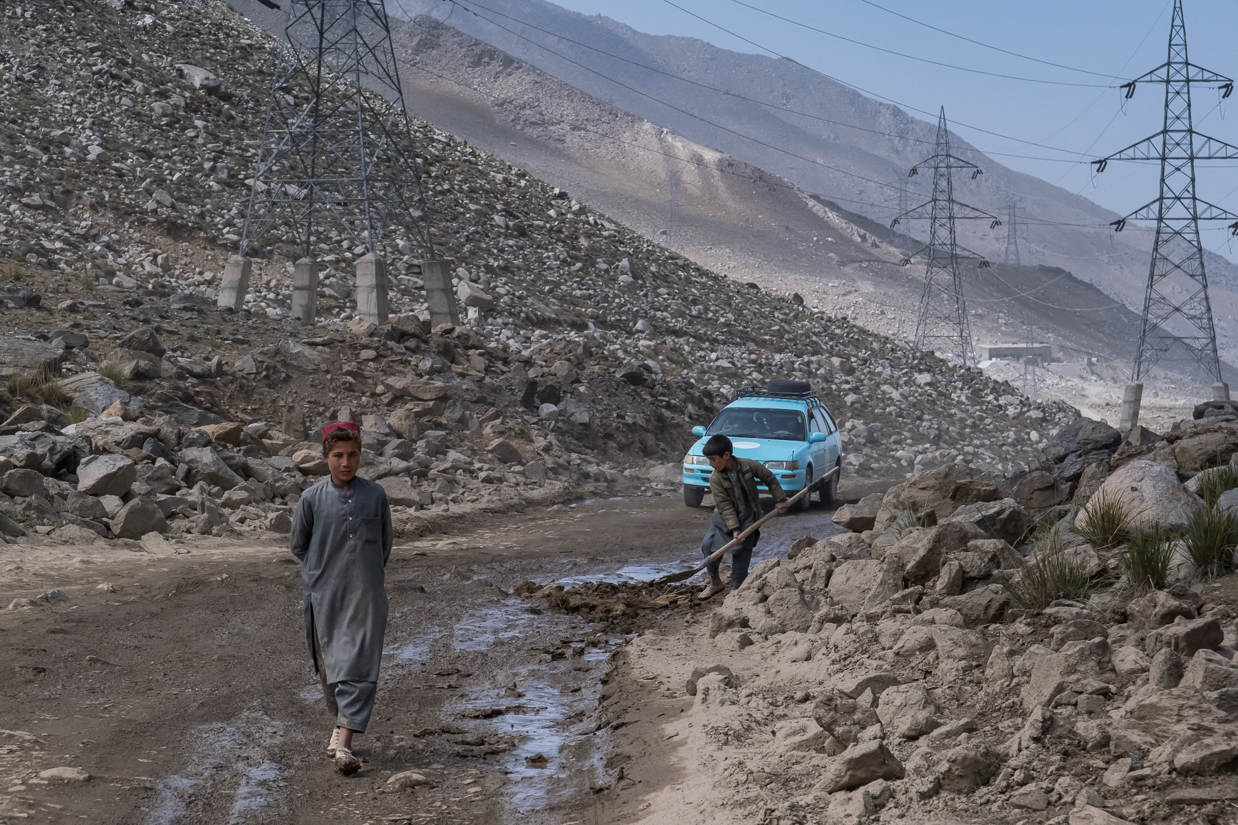 Children filling potholes along the Salang Pass, the main north-south road traversing the Hindu Kush mountain range. Salang, Baghlan, Afghanistan, September 2024