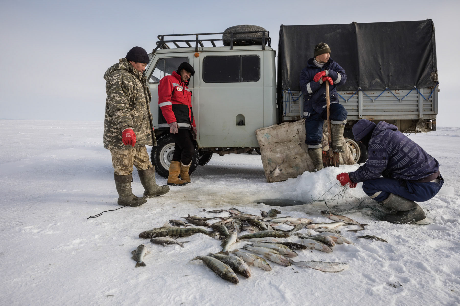 Fishermen at work on the Aral Sea during the ice fishing season. Kazakhstan, January 2019