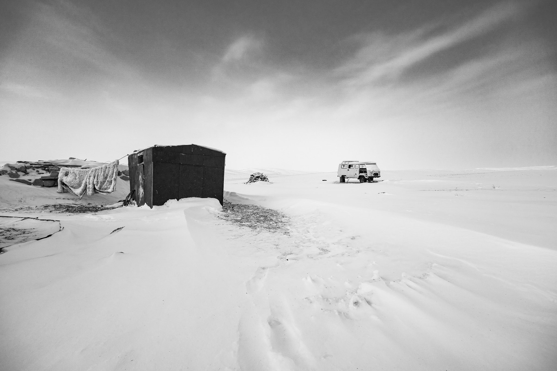 A small settlement of Gers and utility sheds standing against the vastness of the Gobi desert, Mongolia, December 2025