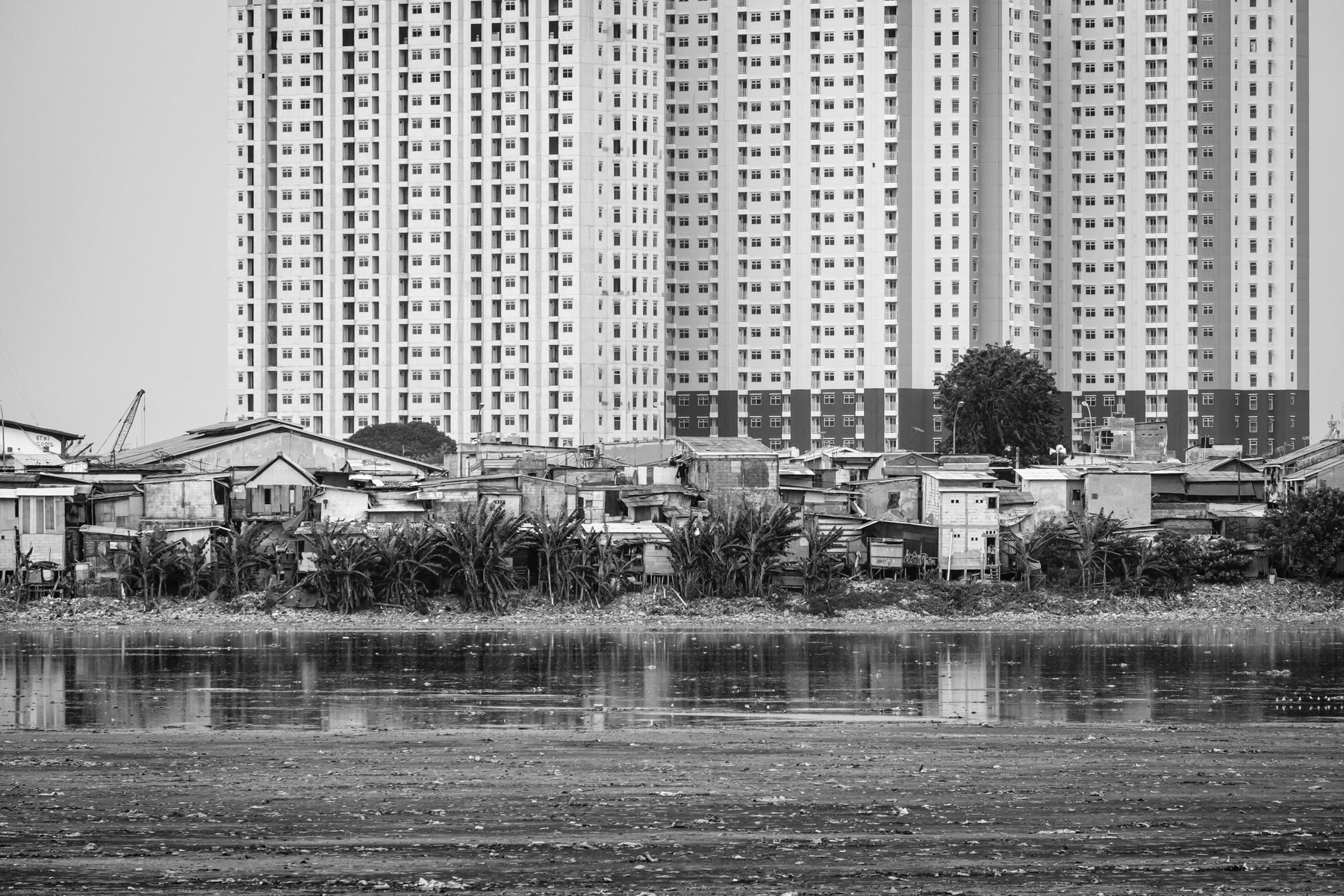 Muara Baru neighbourhood along Waduk Pluit, an artificial lake regulating in- and outflows between the river and the Bay of Jakarta. Muara Baru, Jakarta, Indonesia, March 2020
