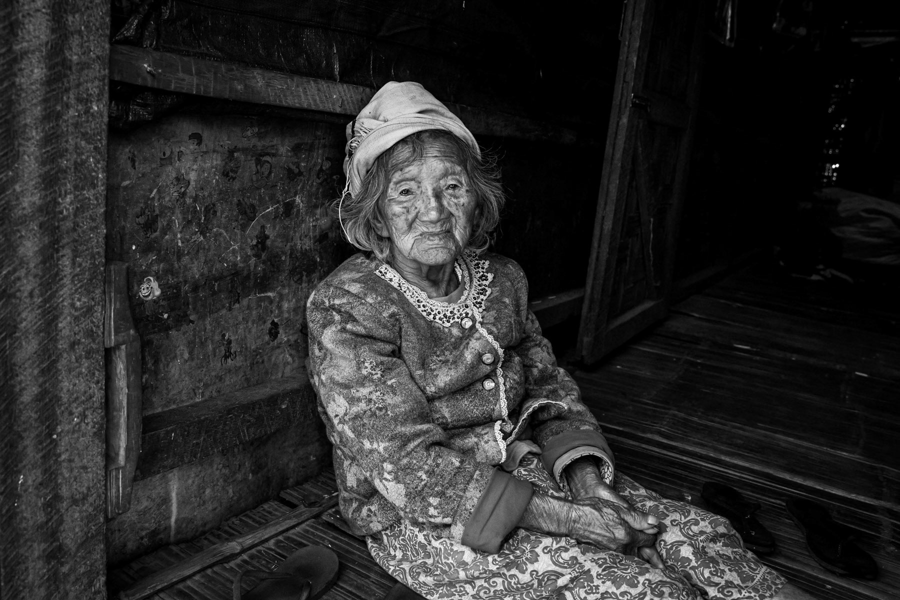 Elderly woman of approximately 100 years old living as an internally displaced person in the sole IDP camp in Puta-o the most northern town of Kachin State and Myanmar near the border with India and China. Puta-o IDP Camp, Puta-o, Kachin state, Myanmar, February 2020