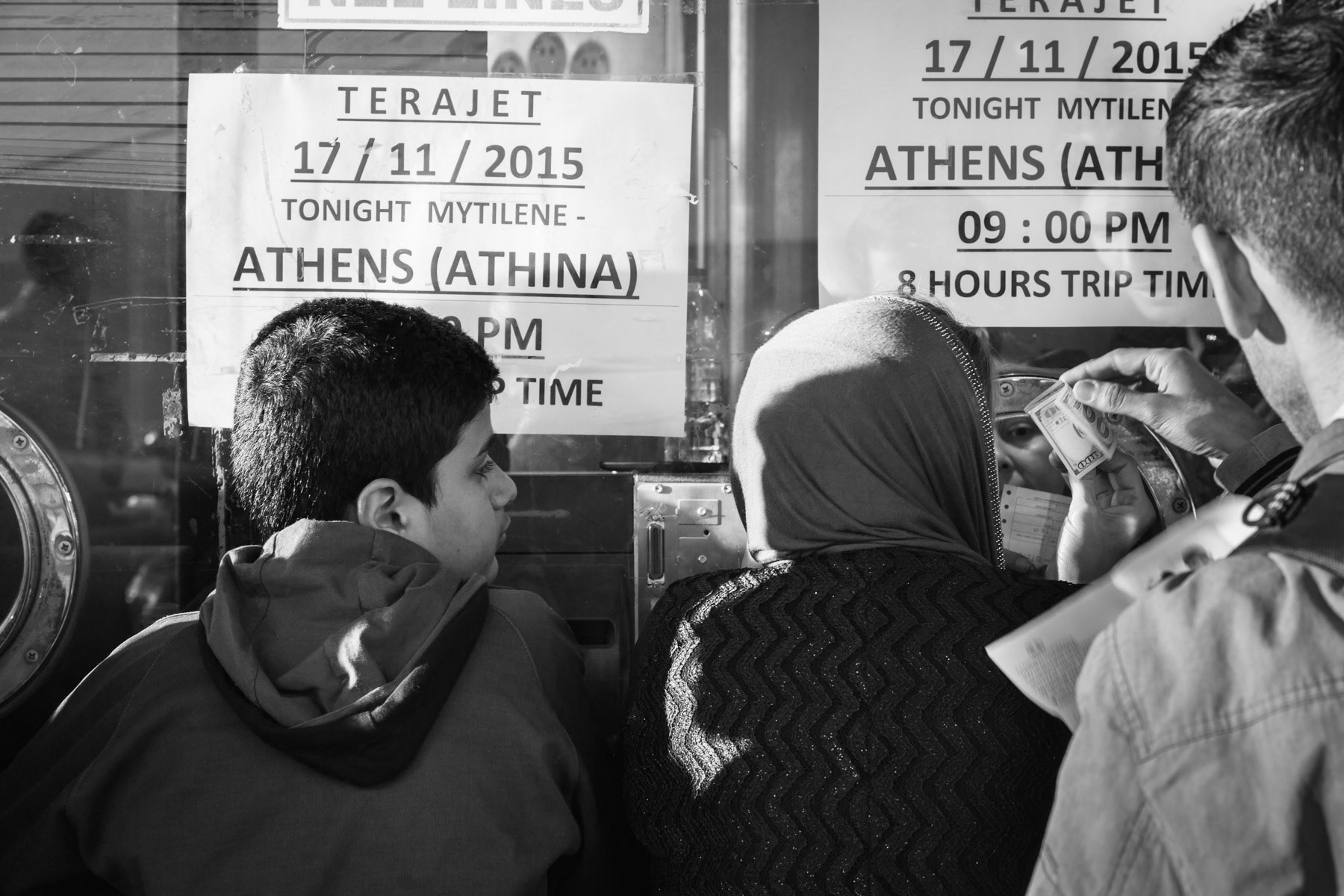 Refugees trying to buy a ferry ticket for mainland Greece, Levbos port, November 2015