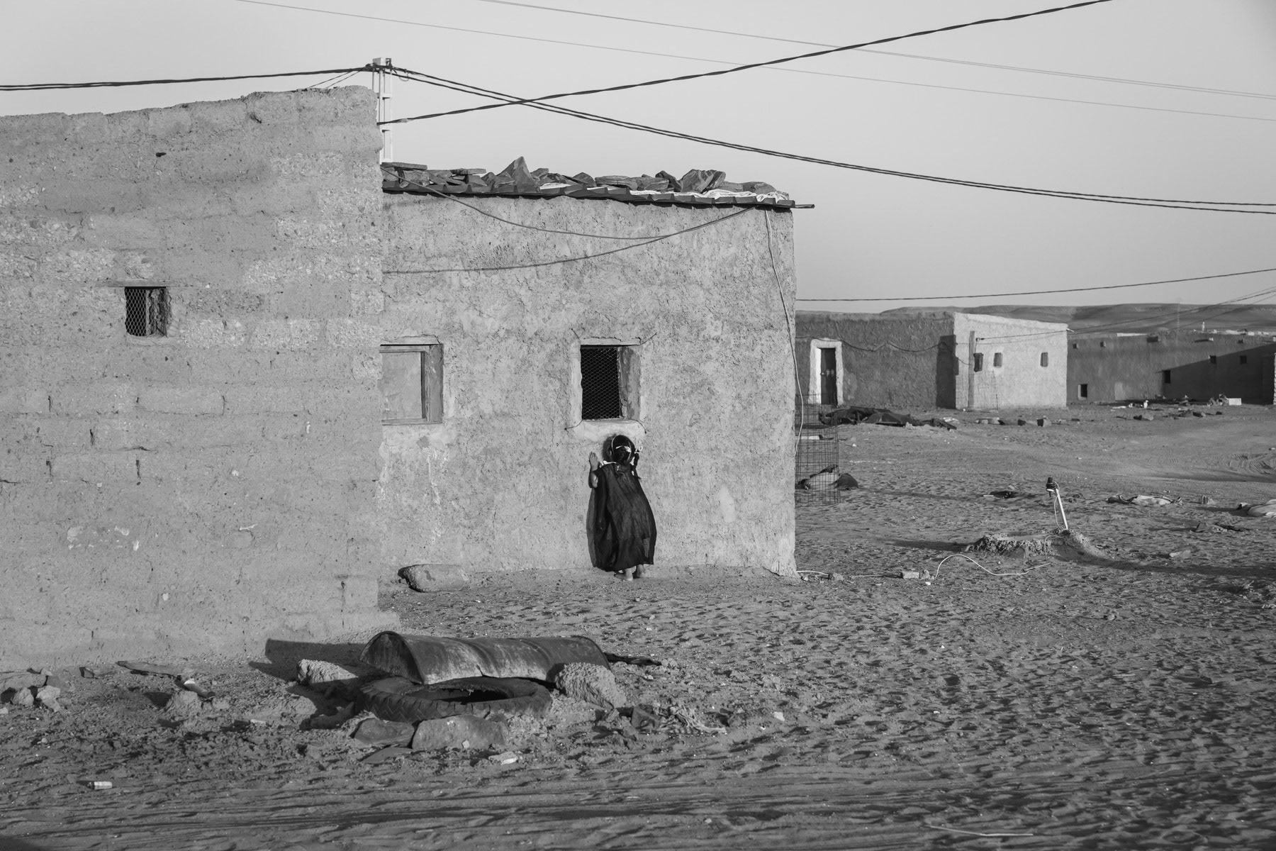 Sahrawi girl playing around her house. Saharawi refugee camps were established in the seventies in an area managed by the POLISARIO, the government in exile of the Saharawi Arab Democratic Republic (SADR). Between 120 and 150,000 refugees from the Western Sahara live in 5 refugee camps in the desert south of Tindouf. Boujdor Refugee Camp, Algeria, October 2021