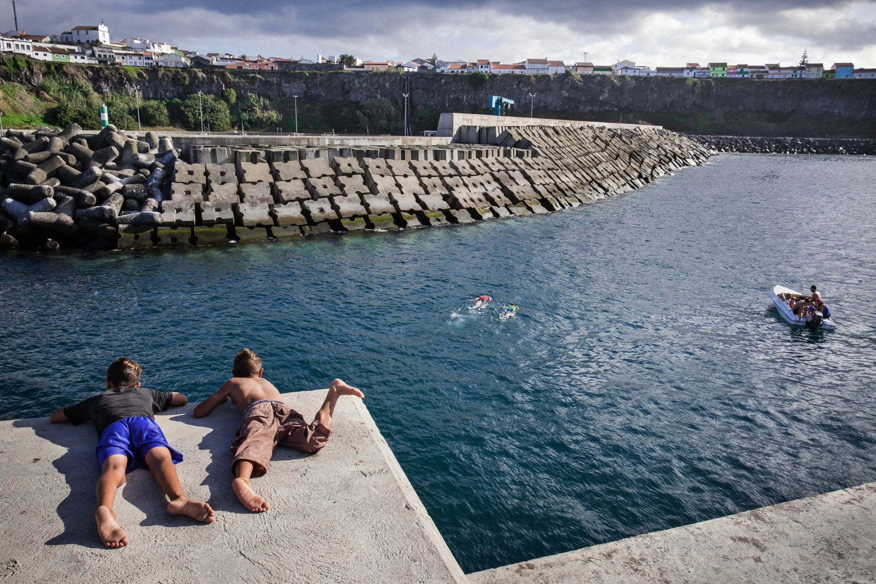 Kids playing and swimming in the port. Rabo de Peixe, Azores, September 2018