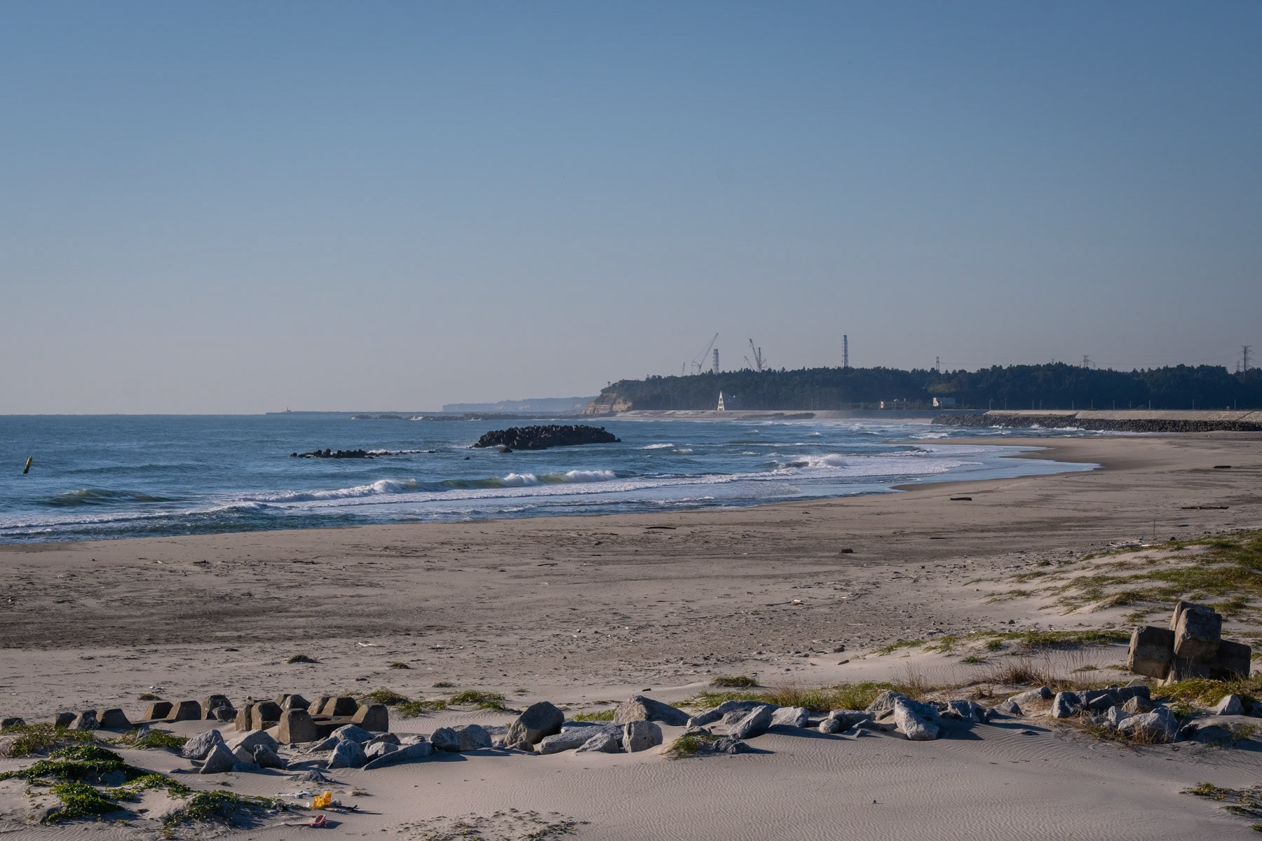 Beach along the Pacific coast beside the Fukushima nuclear power plant that is still in the phase of stabilisation and cooling in order to be eventually dismantled. Twelve years after the disaster there is not enough space anymore to store water that is being used for the cooling of the damaged reactor and is since August 2023 being released after decontamination directly in the ocean. Tomioka, Fukushima, Japan, October 2023