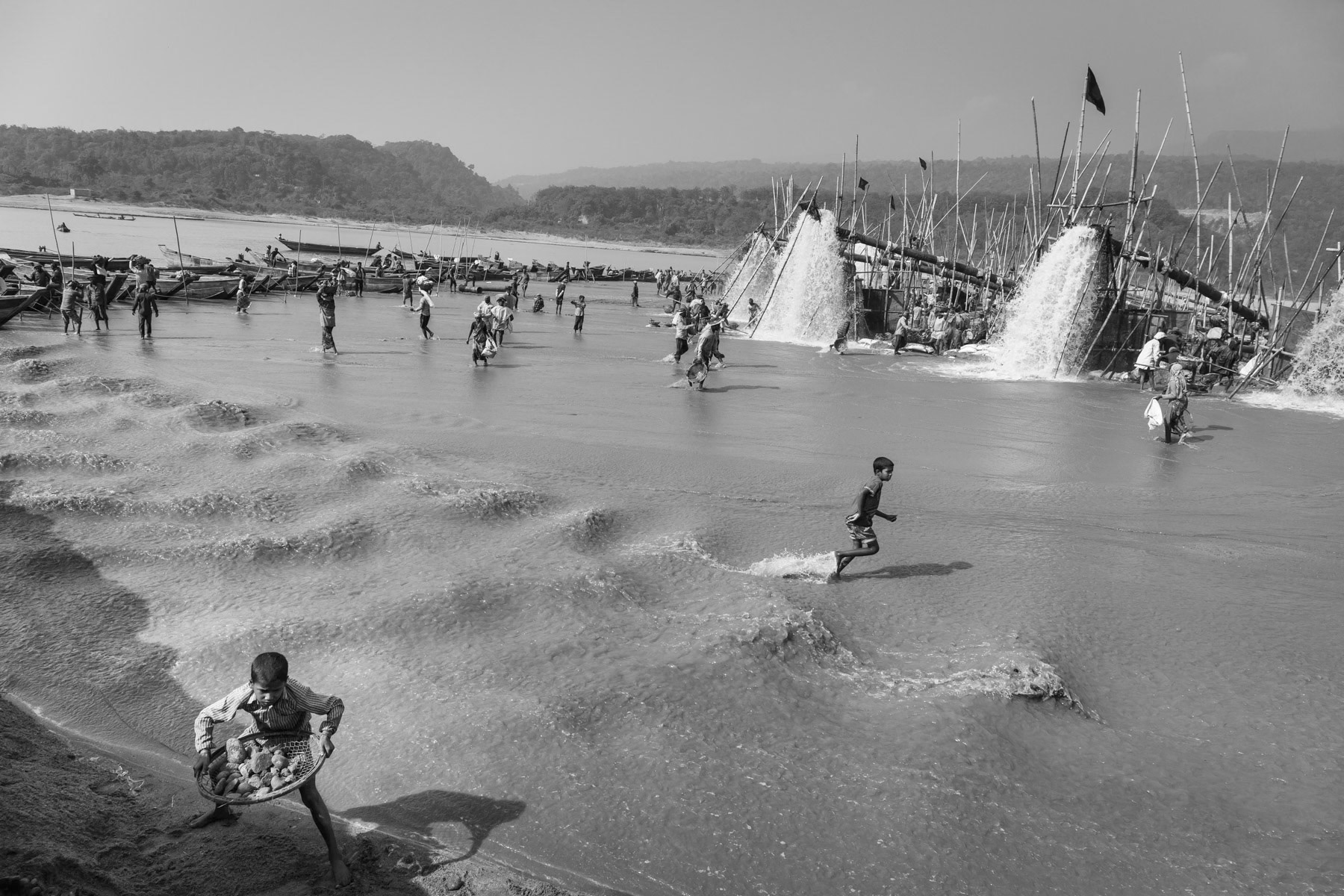 Extraction pumps spilling out water containing stones that are essential to supply the booming construction sector, Dholai river, Bangladesh, December 2015