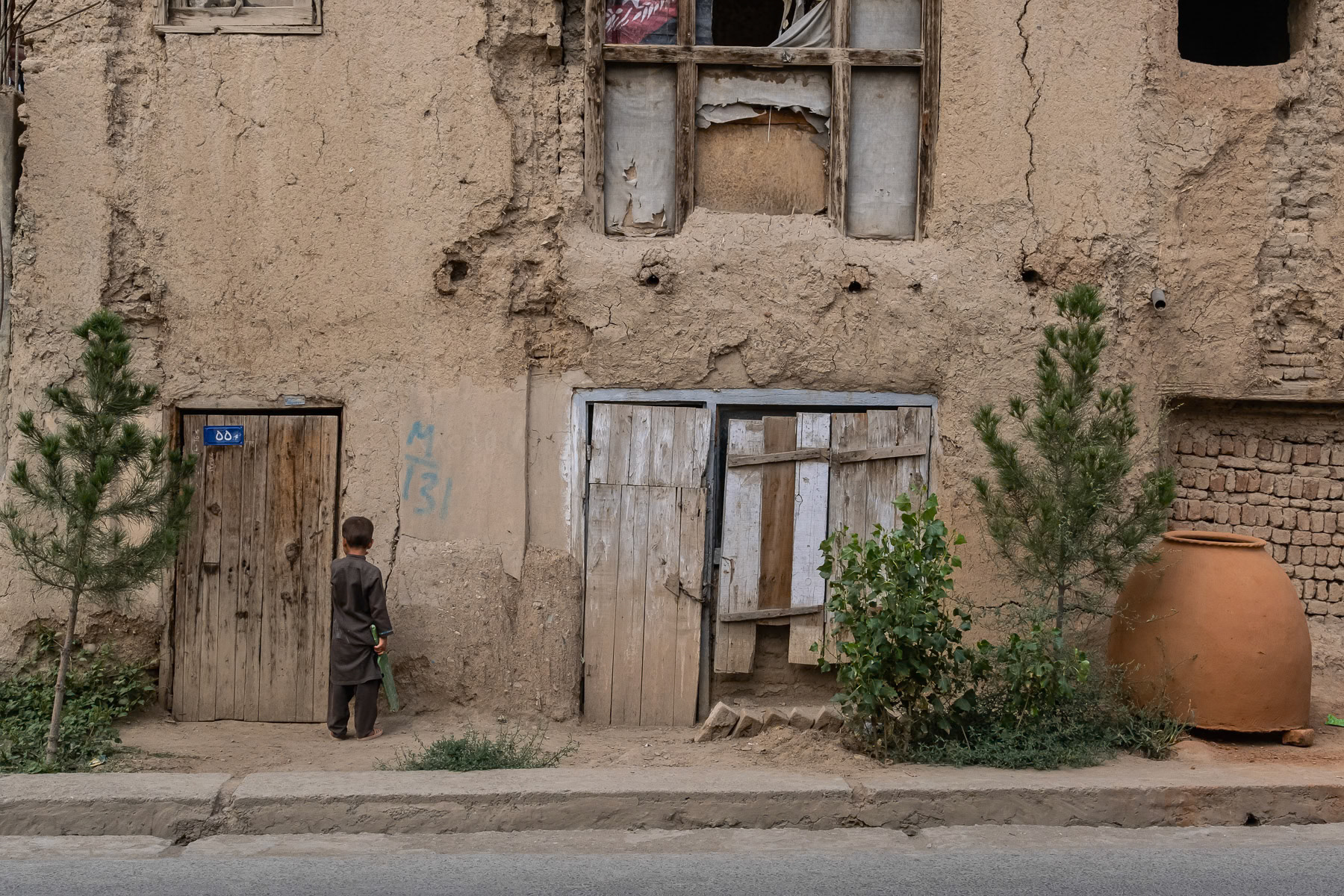 An Afghan boy in a street famous for making traditional bread ovens. Shahre Naow in Kabul, Afghanistan, August 2024