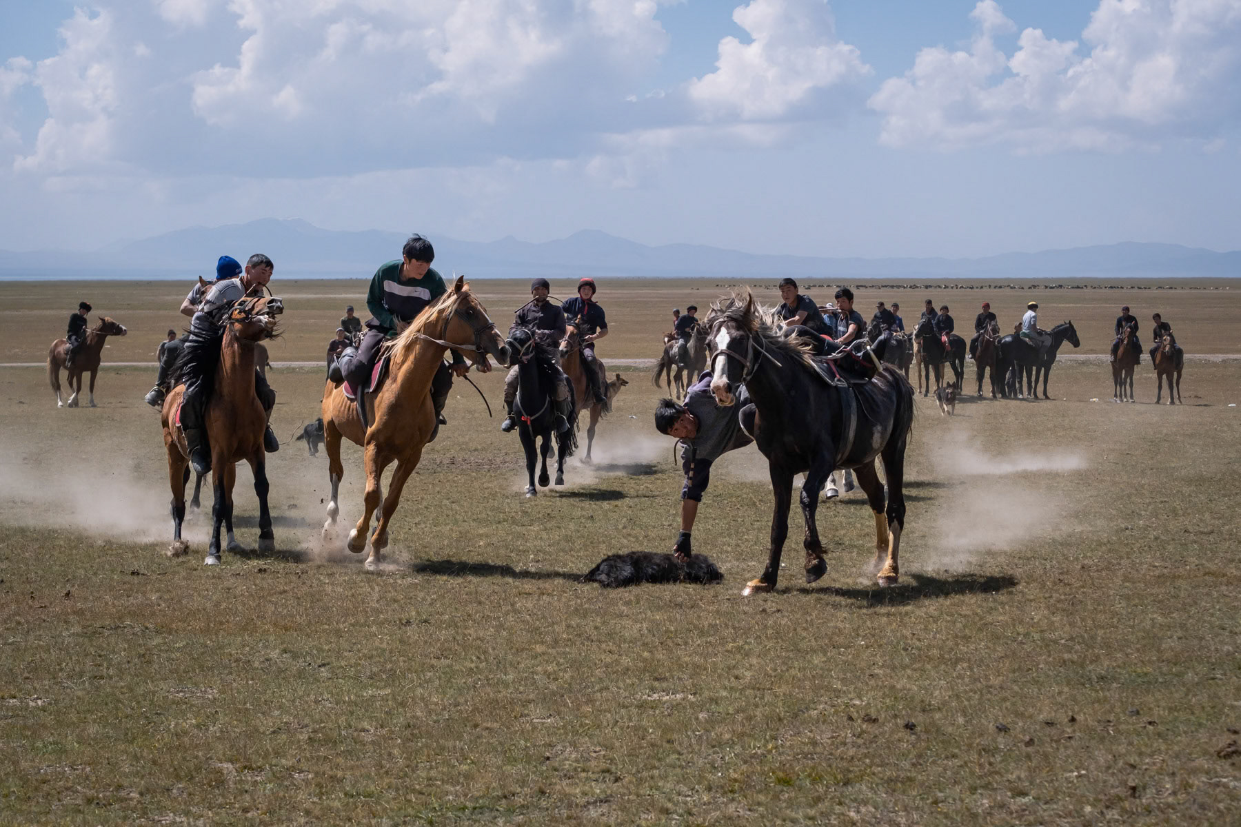 Two teams fighting to take possession of the 'ulak' during a Kok Boru game. The 'ulak' consists of a goat's carcass and needs to be dropped in the opponents' goal in order to mark a point. Son Kul Lake, Kyrgyzstan, August 2021