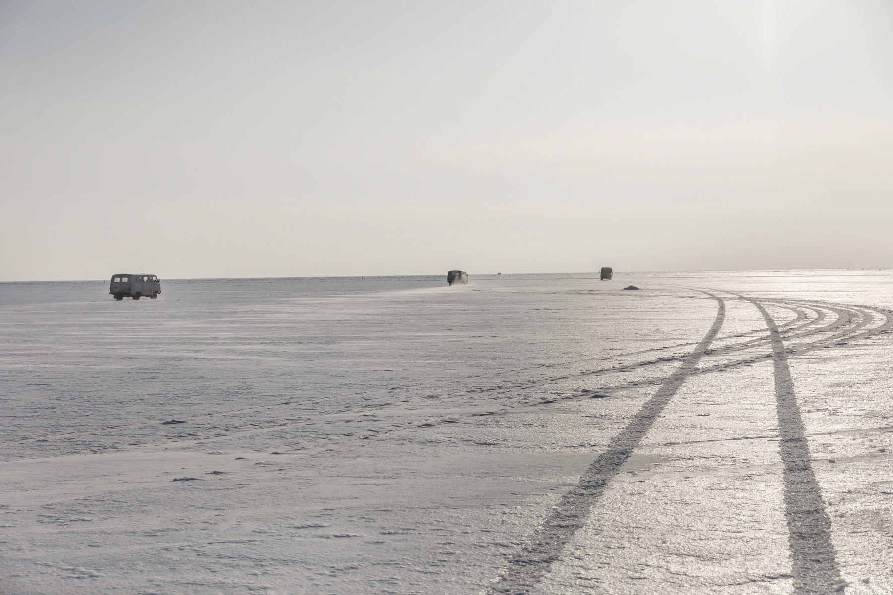 Teams of ice fishermen heading out with their trucks on the frozen Aral Sea, Kazakhstan, January 2019