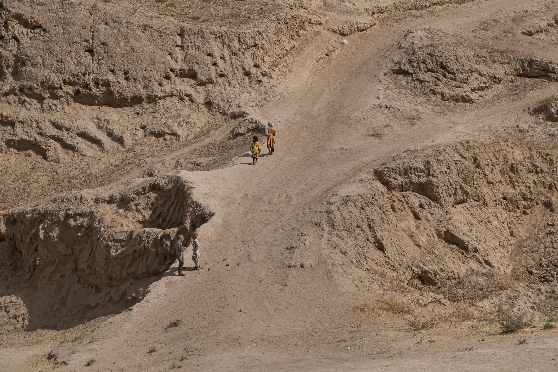 Afghan children walking uphill towards their village. Sulgara Valley, Balkh province, Afghanistan, September 2024