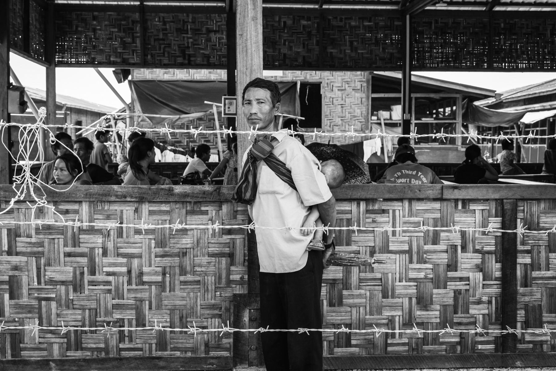 There are over a million Kachin people in northern Myanmar and about 150,000 in Yunan, China. Thousands have sought asylum in Thailand and Malaysia following a long lasting guerilla war between the Kachin Independence Army (KIA) and Myanmar government troops. Kachin were originally animist, however as of 1860, British and American missionaries began converting Kachin people to Baptism and other Protestant faiths. Nowadays, nearly all Kachin self-identify as Christians. The church plays today a fundamental role in Kachin's society and social services for the large displaced population. When Burma achieved its independence, the Kachin people got their own State within Burma along strong assurances of significant regional autonomy. Kachin State is very rich in natural resources such as tropical timber, gold, jade and is located in the "Golden Triangle" known for its opium production. Despite autonomy the Burmese government and later the military junta intervened heavily in Kachin's affairs depriving it of its natural wealth and access to development funds. This led militant Kachin leaders to take up arms and form the Kachin Independence Army in 1961, and starting a guerilla war against the government. The war continued relentlessly until a cease-fire in 1994 that lasted until 2011. Despite repeated rounds of negotiations and short-lived cease-fires, fighting has continued with regular occurrence displacing over a 100,000 ethnic Kachin since 2011. Human Rights groups have collected testimony of severe human rights abuses such as land confiscation, mass rape and summary executions by government troops against the Kachin people. As a result of the violence and human rights abuses over a 100,000 ethnic Kachin live in camps for internally displaced persons (IDP) along the Chinese border in KIA controlled territory and in IDP camps in government controlled territory. The humanitarian and psychological situation in the camps is alarming and extremely precarious in KIA controlled territory where humanitarian aid and food only reaches the area sporadically when government troops do not block all access. The border with China is also closed for humanitarian convoys leaving the IDPs in KIA controlled territory in an extremely vulnerable situation and in usually very romote mountain areas. In meanwhile the Myanmar military hinges on their control of these border areas that are extremely lucrative in terms of natural resources (jade and gold), illigal substances (drugs), plantations (banana) and Chinese large scale development projects as the Mytsone dam on the Irrawaddy river. Lambraw IDP camp where 557 people live since April 2018 after being displaced from their village 25 Km away. Namta, Kachin, Myanmar, September 2019