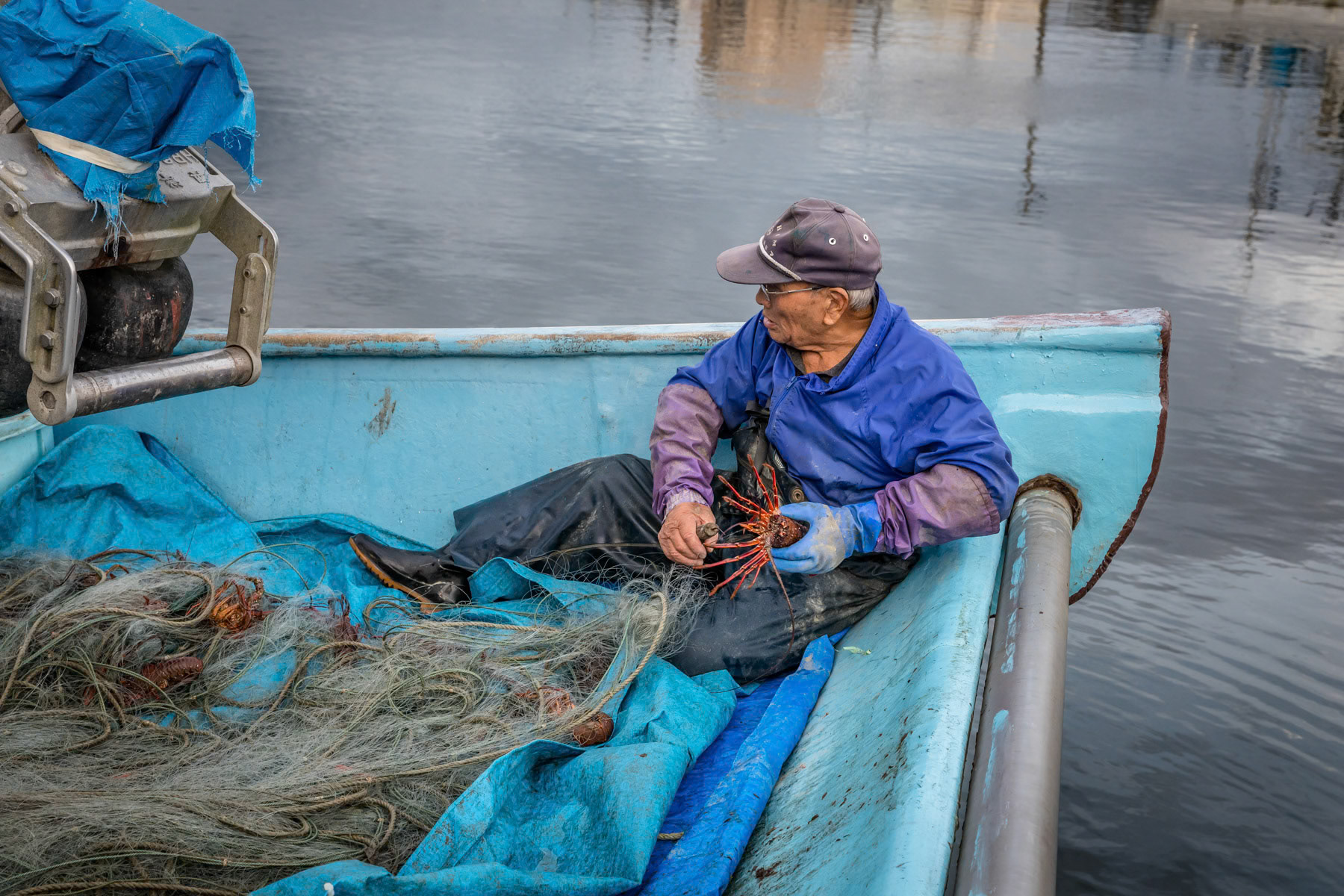 A fisherman cleaning his nets. The fishing community has been gravely affected by the Tsunami and many died trying to save their boats. The surviving fishermen have been banned from fishing for many years after the nuclear catastrophy. Only in the past couple of years has fishing being allowed again under very stringent radiation controls. Onamaha fishing port, Fukushima Prefecture, Japan, October 2019