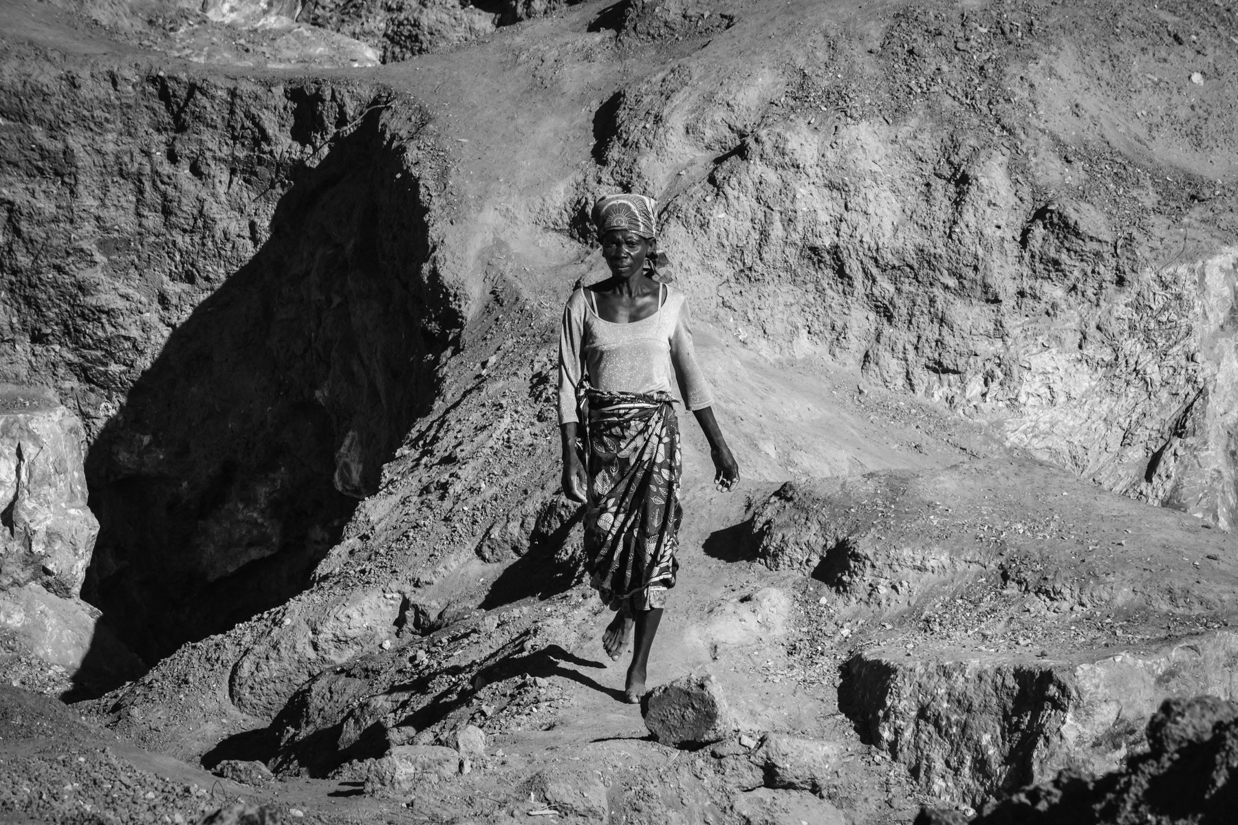 A woman working at the Mukululu small scale open pit mine, started by the local authorities as a community empowerment project. Mainly lead sulfide and magnesium oxide are being found and bought up by middle men that will make the main profit, the women, men and children from the local community doing the daily hard labour make hardly enough money for their basic food needs. Mukululu community, Kabwe, Zambia, May 2021