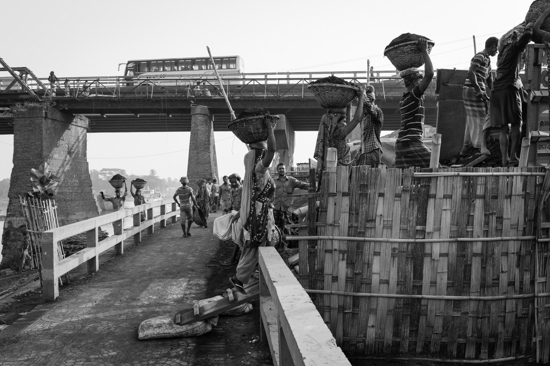 Coal being carried from the boat directly into the waiting trucks. Gabtoli terminal is one of the biggest transport hubs in Dhaka, linking the riverways and main roads. May 2015