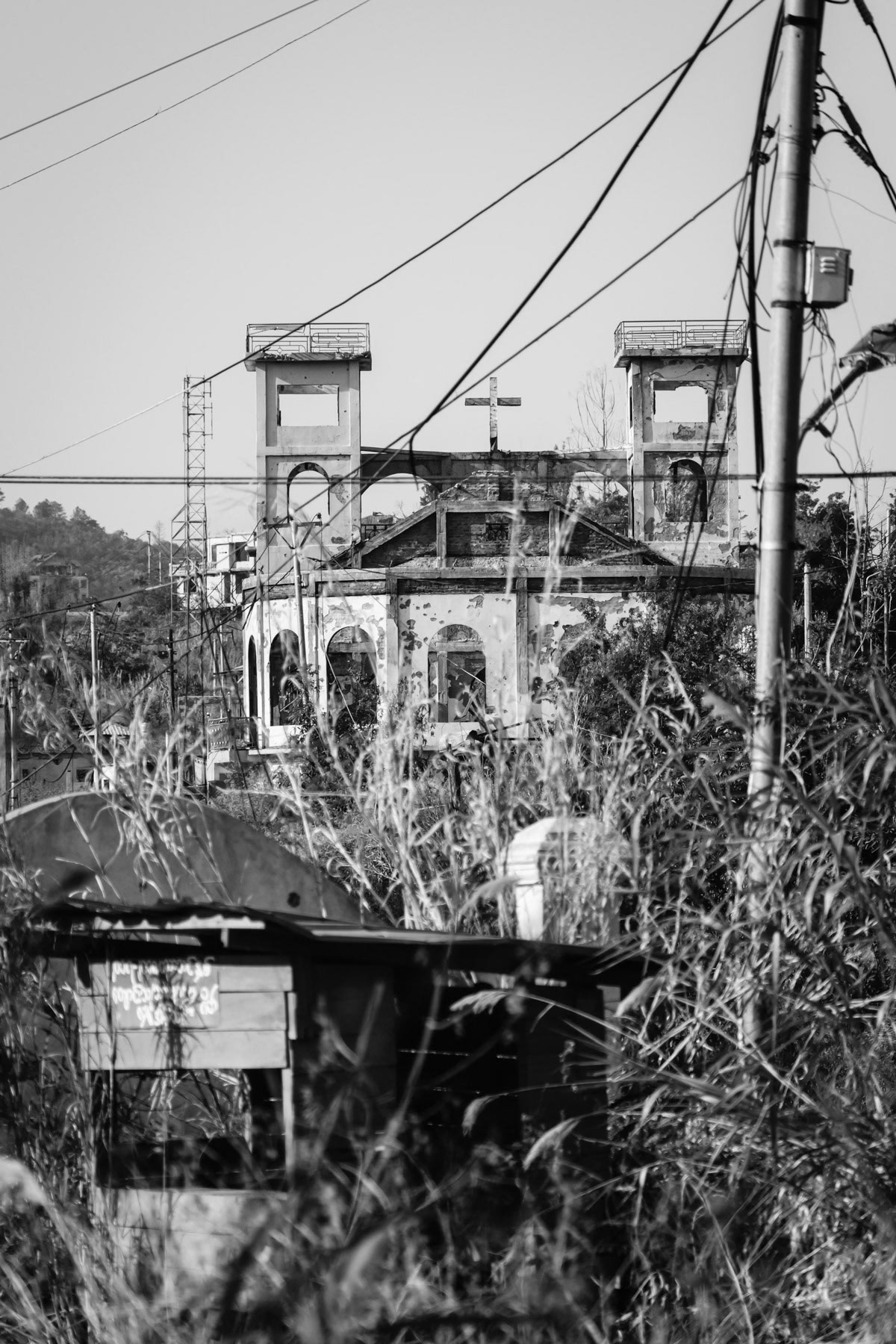 Thantlang, a town of 12,000 before the war is now completely evacuated of its civilian population. The town has been completely destroyed and mostly burned to the ground. Until this day the town is divided between a Myanmar military conrolled part and the other half controlled by the Chin Defense Forces. Merely a couple of hundred meters separates them downtown. Some of the most violent and intensive combats in Chin State are taking place to this date in Thantlang. Thantlang frontline, Chin State, Myanmar, April 2024