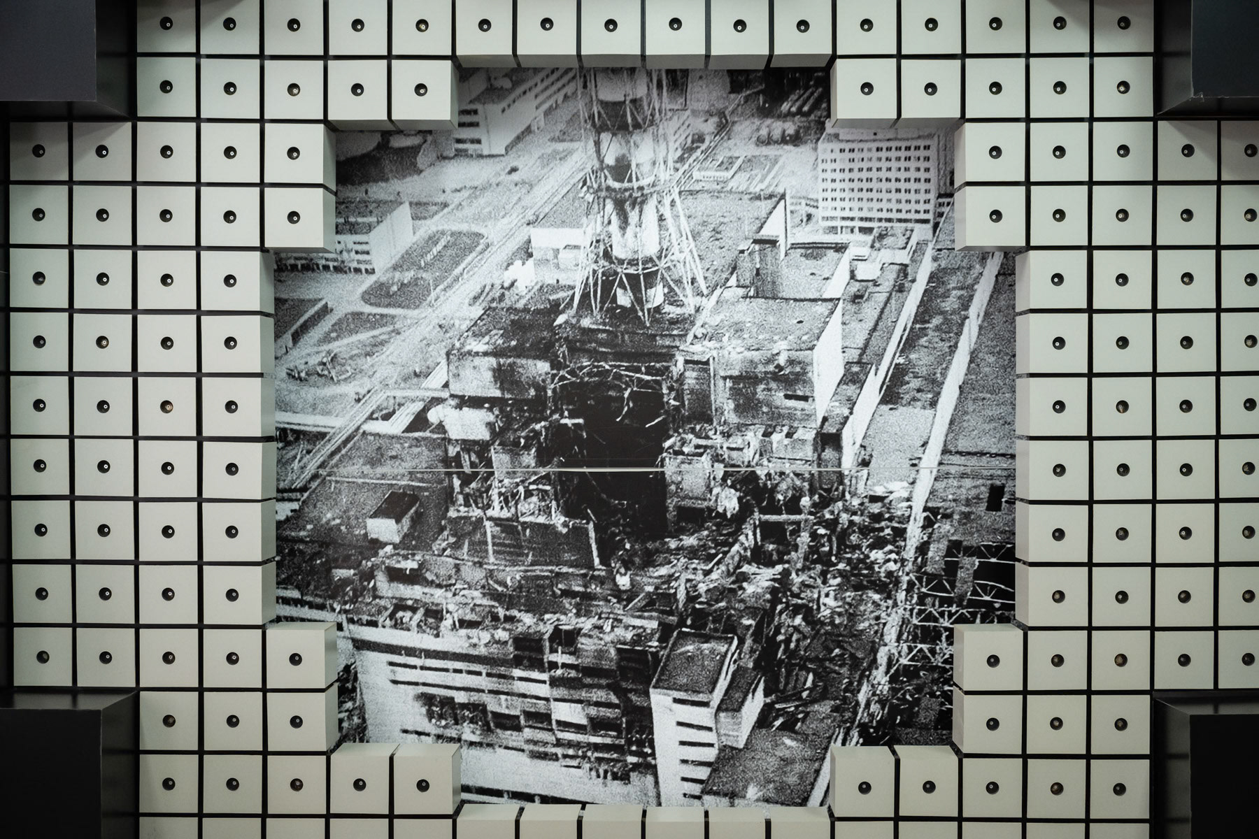 On April 26, 1986, the biggest nuclear accident in mankind's history has happened at Reactor block 4 of the Chernobyl Nuclear Power Plant. It happened during an experiment, which was intended to test a possible cooling method in an emergency situation. After enormous efforts in decontaminating and repairs, block 1, 2 and 3 resumed its operation until 2000 when the last block was decommissioned. More than 30,000 people were evacuated within 36 hours after the disaster from what is known as the Chernobyl exclusion zone. The zone covers a territory of 2,600 km2 (the Ukranian side), where 96 evacuated villages, towns and cities are located. In terms of radiation safety, there are 3 areas within the zone: the buffer 30 Km area, the internal more polluted 10 Km area and a livable area, where the Chernobyl personnel lives and stays in weekly shifts and the 'Samosely' or self settlers that live there permanently. 'Samosely' are residents of the 30 Km area where there present is tolerated insofar they were living there before the accident in 1986. Less than 200 are still alive and are mainly well over 75 years and women. As the zone is large they live mostly isolated one of the other. Most remain in the zone even during the winter months, their children and grand children live outside the zone in nearby cities or Kyiv. Samosely have all in comon that they wish to remain on their ancestral lands despite all odds and challenges. A photograph of the exploded reactor number 4 dated shortly after the disaster at the Chernobyl nuclear power plant on 26 April 1986. Chernobyl Museum, Slavutych, Ukraine, August 2021
