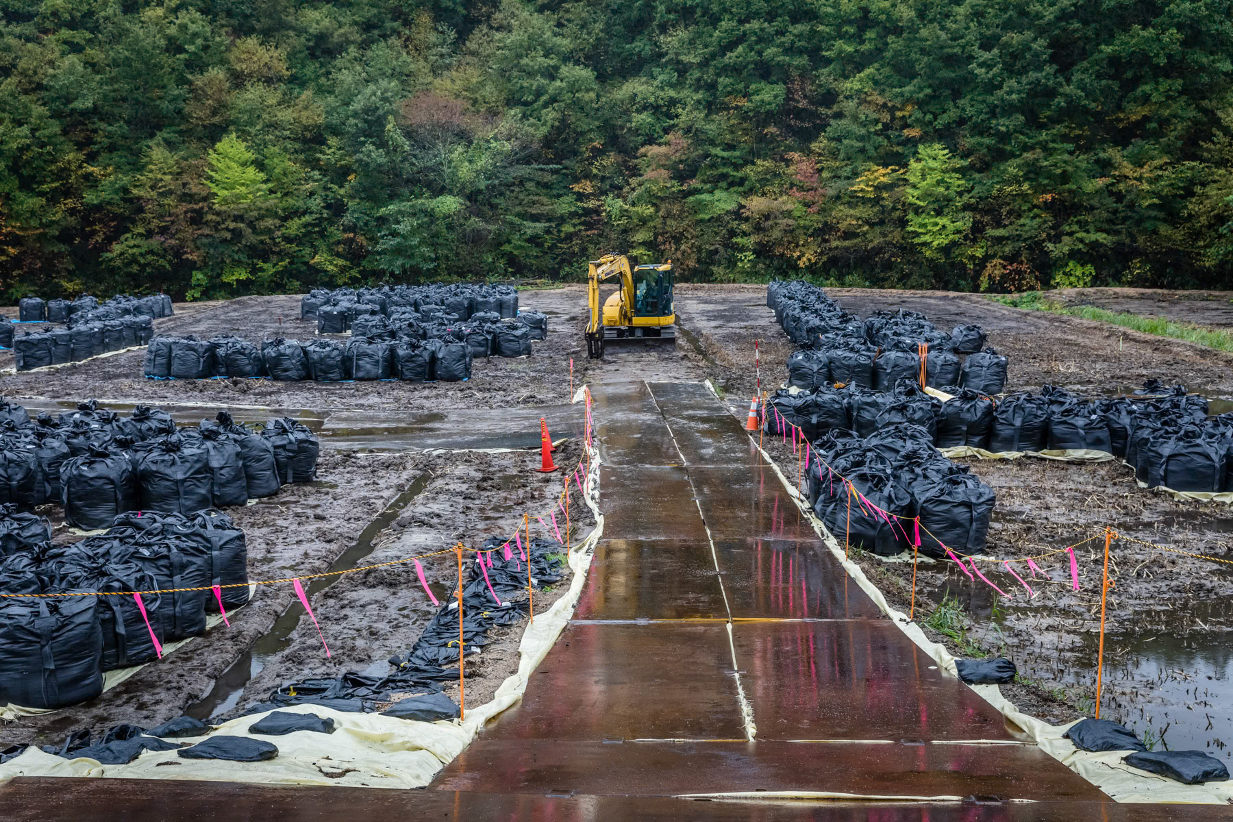 Sealed off area along route 50 used to store contaminated soil removed from newly accessible places. The entire area in the woods and mountains are no go zones as radiation levels are still to high. Those areas in the hinterland will most likely remain off limit forever. Route 50 between Namie and Katsurao. Fukushima Prefecture, Japan, October 2019