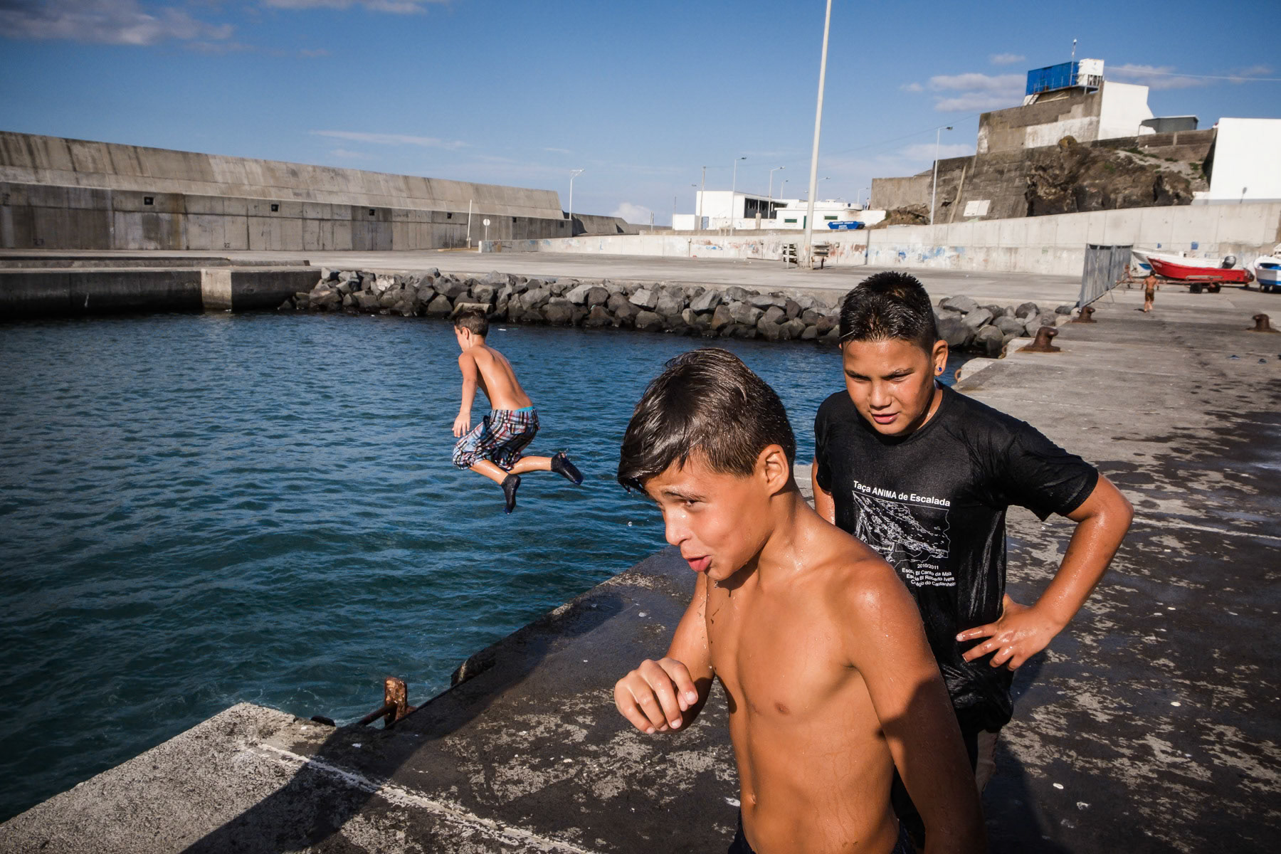 Kids playing and swimming in the port. Rabo de Peixe, Azores, September 2018