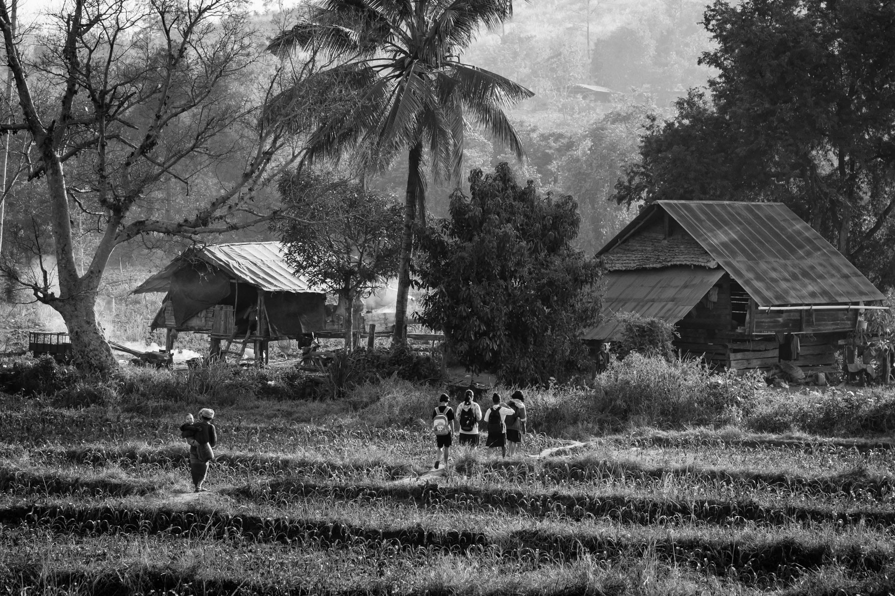 Karen children going to improvised schools along the Thai border. The schools operate in houses or in the open under trees and not in school buildings who are frequently targetted by airstrikes by the military regime. Htee Baw Kaw IDP camp, Kayin State, Myanmar, January 2024