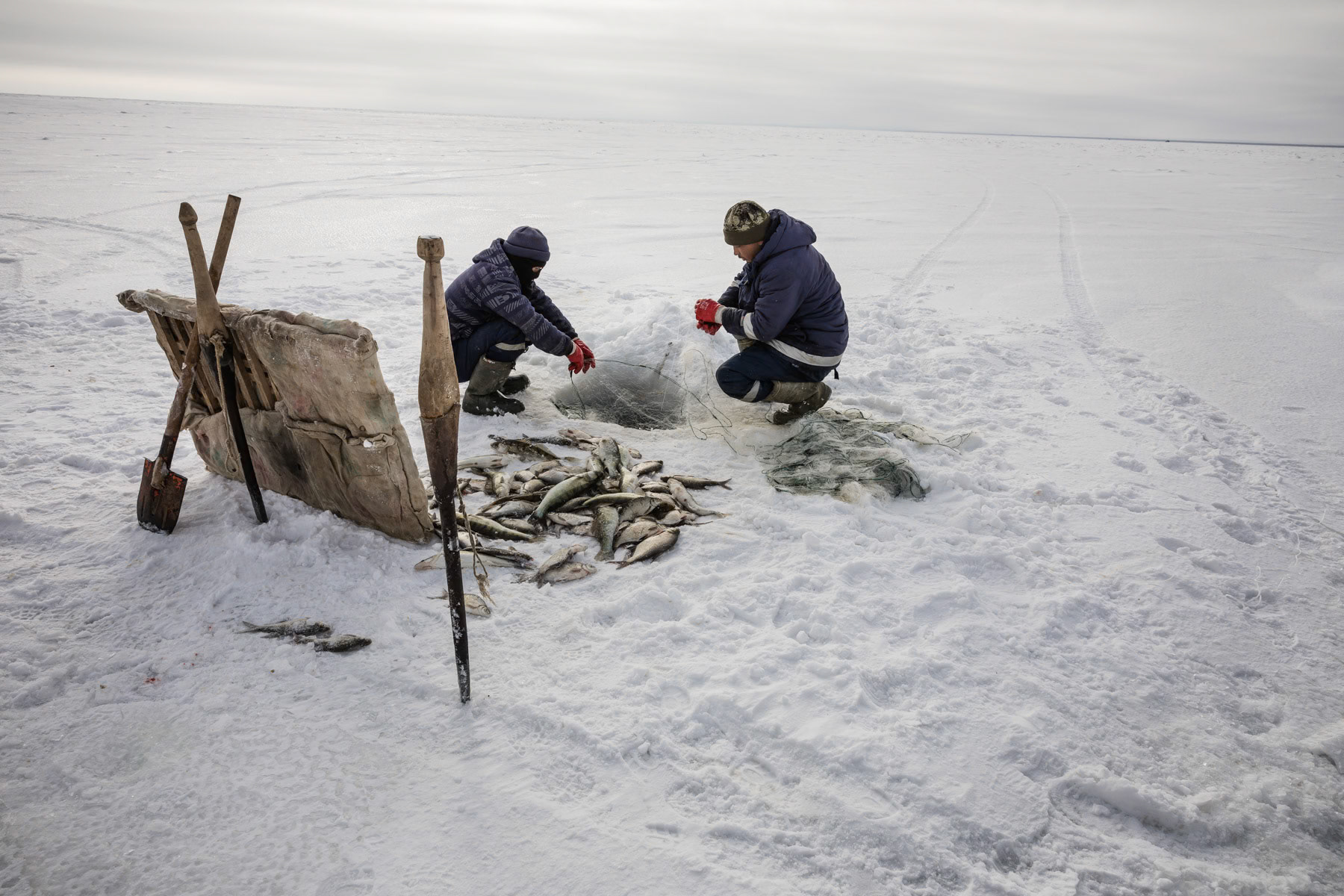 Fishermen at work on the Aral Sea during the ice fishing season. Kazakhstan, January 2019