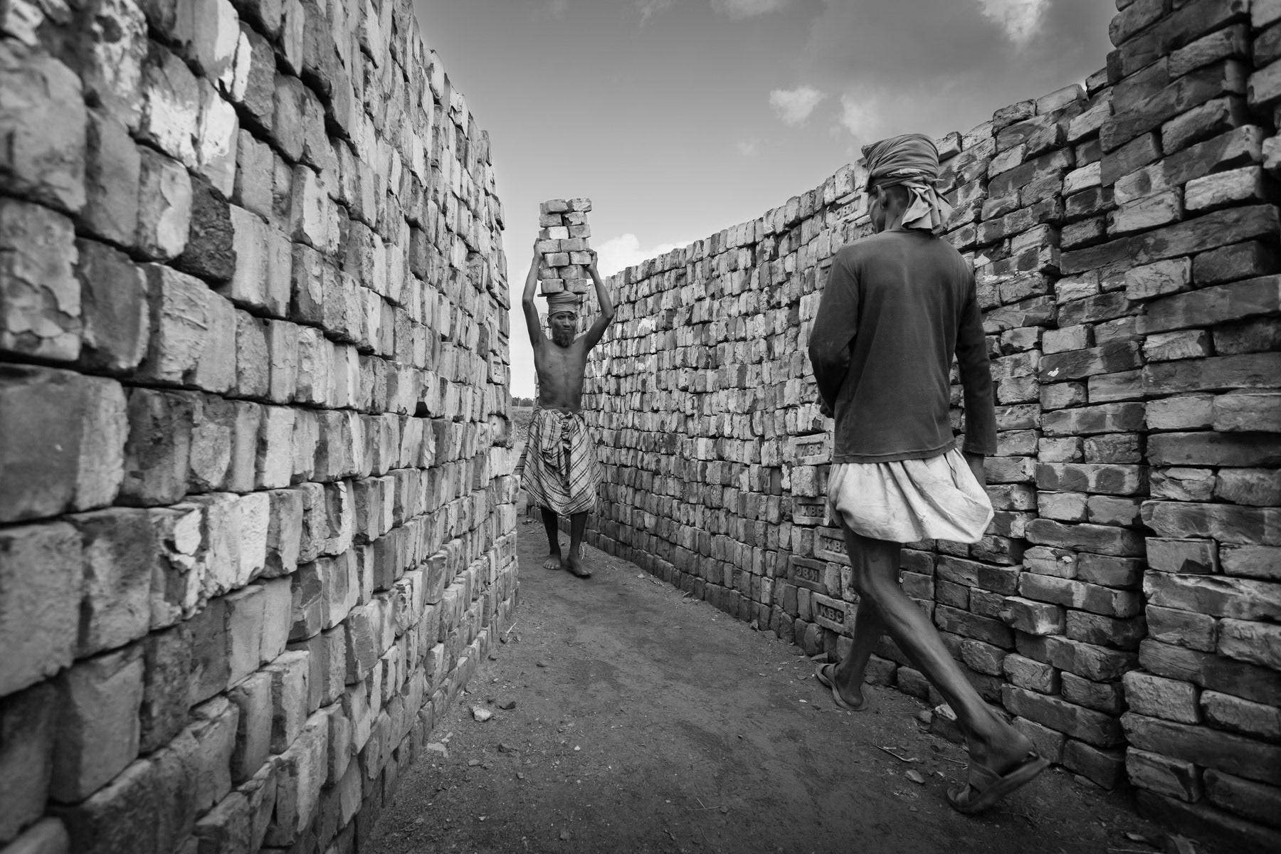 Brick kiln workers carrying heavy loads, Khulna brick kilns, Bangladesh, May 2015