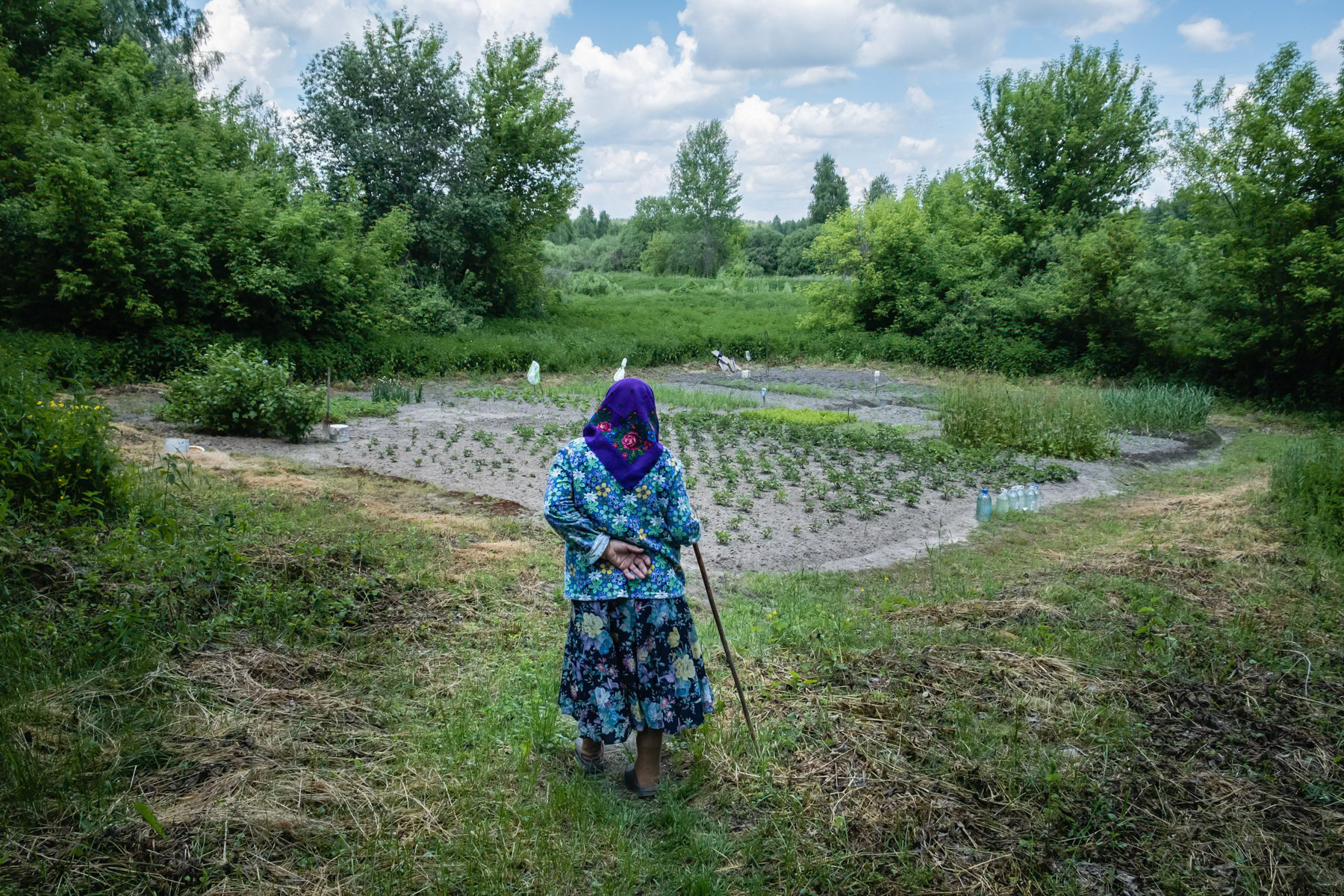 Gania (Hanna), 88 years old, going to her vegetable garden. She has always lived in Kupovate village except for 18 months when she was evacuated after the nuclear reactor explosion in 1986. Kupovate, Chernobyl exclusion zone, Ukraine, June 2021