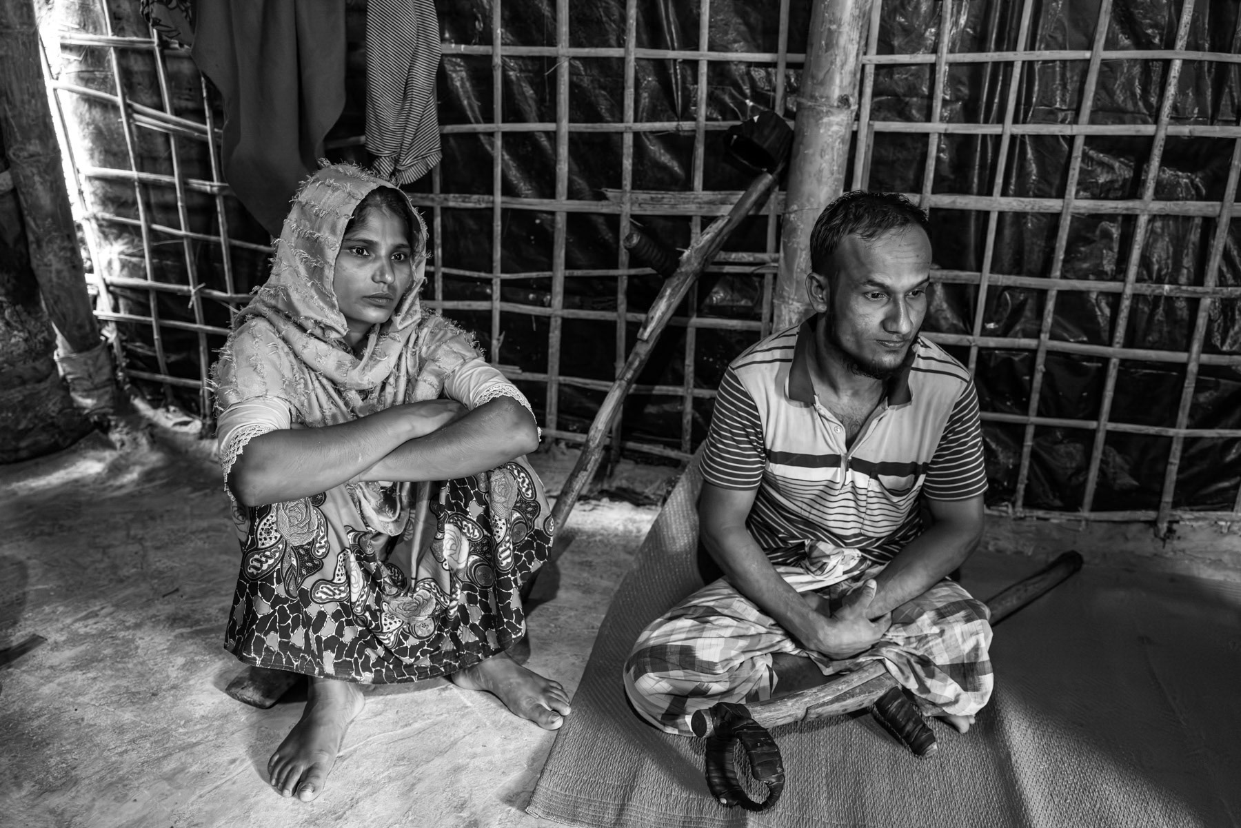 Abu Rahim, 32, from Lawidon village near Buthidaung, sits with his wife as he recounts losing his leg when the Arakan Army shelled their community in March 2024, shortly after ordering residents to evacuate. Dozens were killed and many more injured. Evacuated by the Arakan Army to Sandu village in Rathedaung Township, he was amputated in their medical facility and remained there for a year with other displaced Rohingya. He describes widespread extortion of villagers who were forced to contribute to the armed group’s war effort despite having lost everything. He arrived in Bangladesh in June 2025. Kutupalong refugee camp, Ukhiya, Bangladesh, September 2025