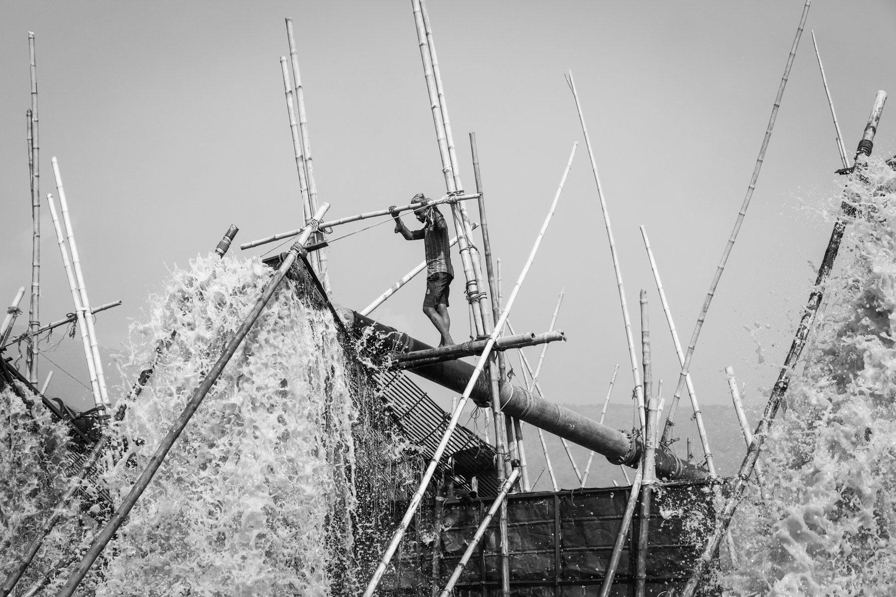 Extraction pumps spilling out water containing stones that are essential to supply the booming construction sector, Dholai river, Bangladesh, December 2015
