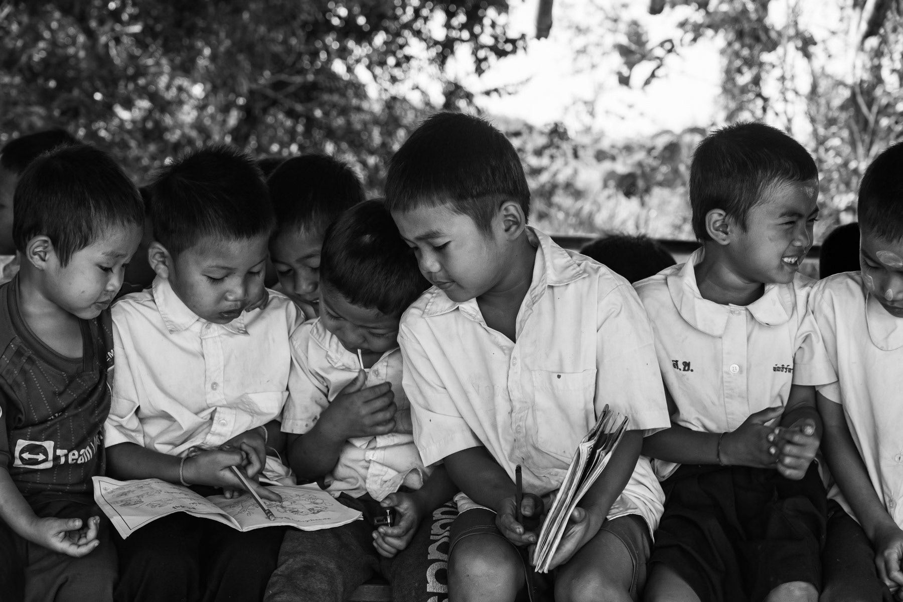 Karen children studying in improvised schools along the Thai border. The schools operate in houses or in the open under trees and not in school buildings who are frequently targetted by airstrikes by the military regime. Htee Baw Kaw IDP camp, Kayin State, Myanmar, January 2024