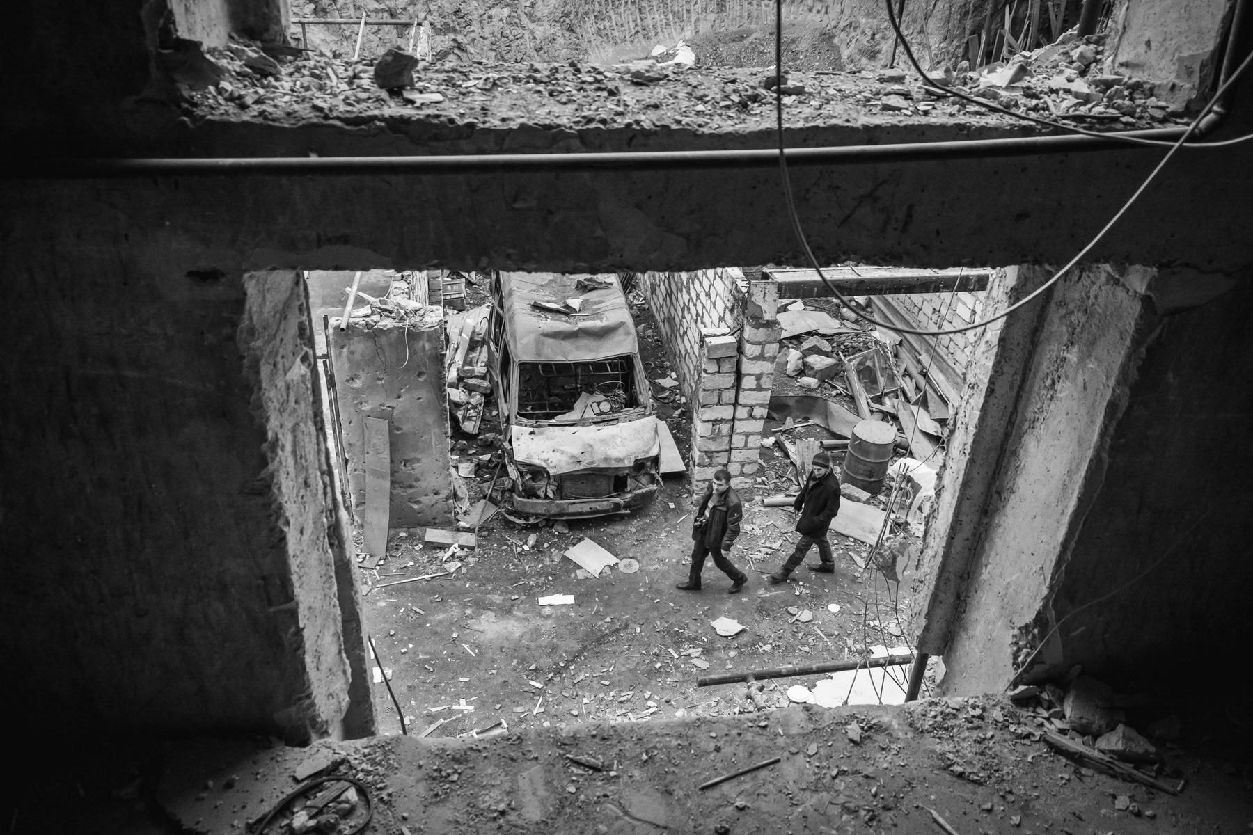 A shelled appartment block near a power station line. Starting on the 27th of September 2020, the Azerbaijani artillery and drones kept Stepanakert, the capital of Nagorno-Karabakh, a town with a population of 50,000, under fire for 44 days. Human Rights reports highlighted the use by both sides of banned munitions such as cluster munitions and artillery rockets that did not distinguish between military targets and civilian structures. Armenian forces have also hit several times densely populated areas with rockets within Azerbaijan, in particular the second largest city of the country, Ganja. Stepanakert, Nagorno-Karabakh, December 2020