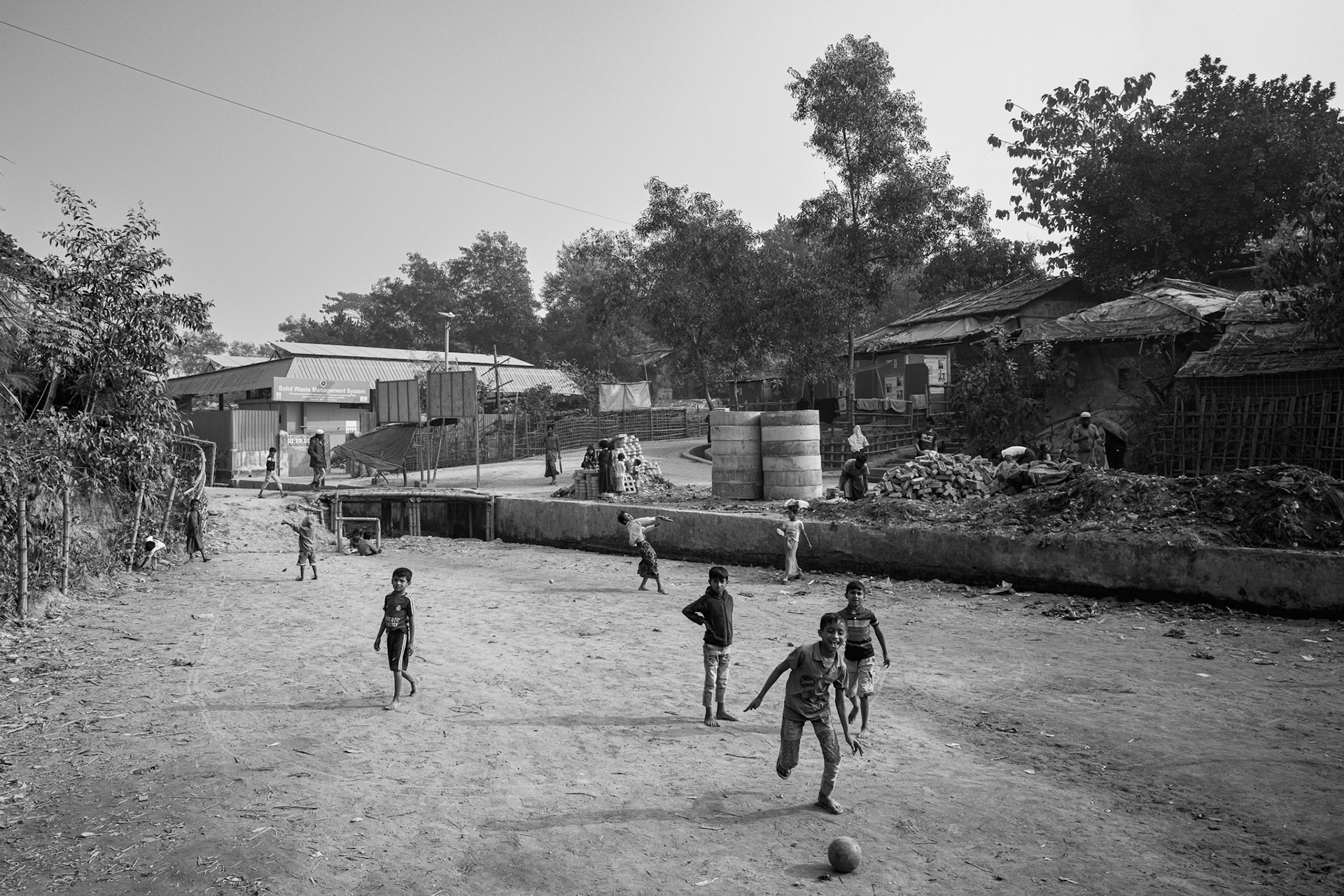 Children playing in a rare open clearing. With nearly half of the camp population being minors, the lack of safe recreational and educational spaces is a critical issue for a generation growing up in exile. Kutupalong camp, Bangladesh, January 2026