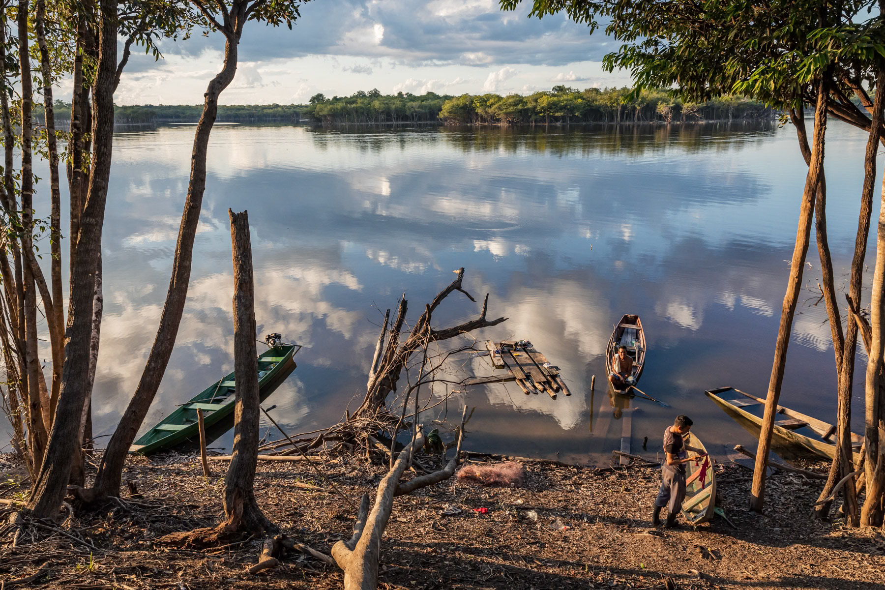 A villager repairing his canoe along the Urubu river in the Amazonian rainforest, Amazonia, Brazil, November 2020