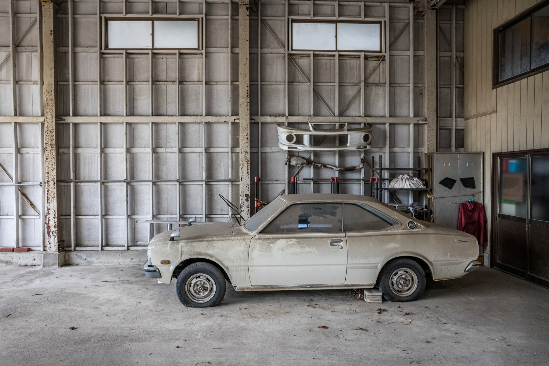 Abandoned garage, idle since 11 March 2011 when an earthquake, a tsunami and a nuclear reactor meltdown obliterated the region. Namie, Fukushima Prefecture, Japan, October 2019